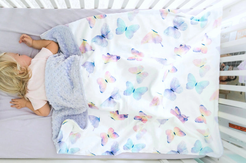 Baby & toddler blanket with colorful butterfly pattern in crib.