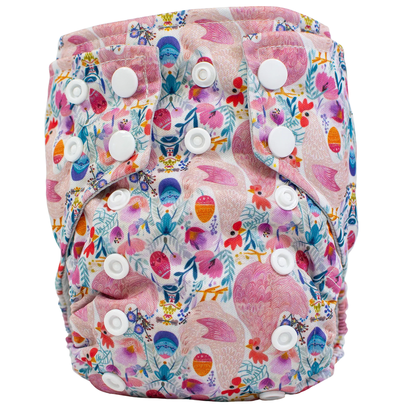 Tiny Tushies Newborn AIO Cloth Diaper with colorful floral pattern, white snaps, and pocket opening for extra absorbency.