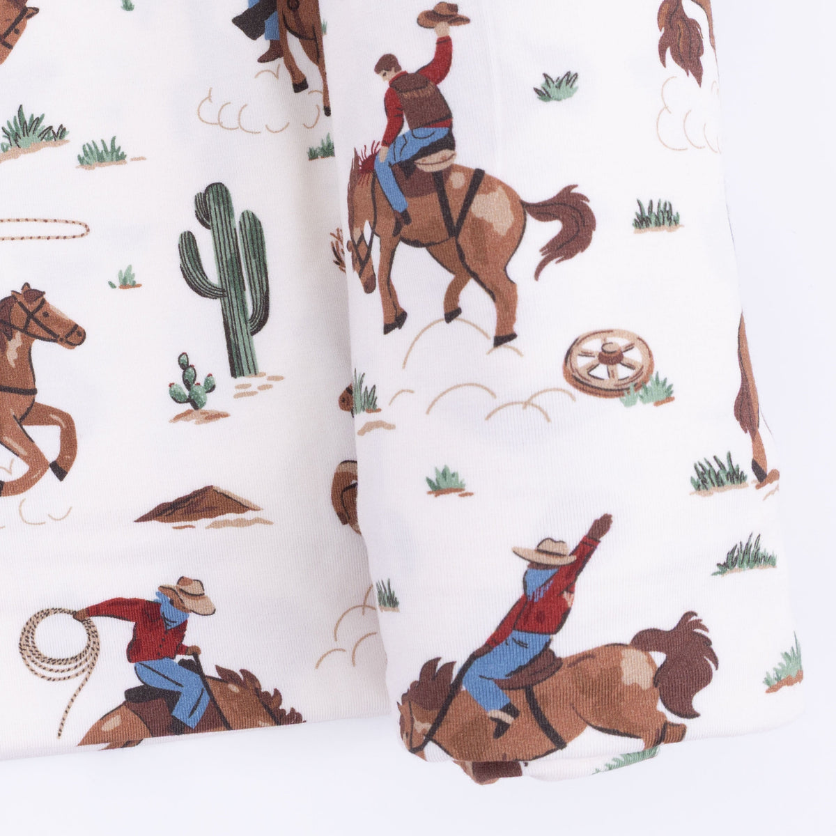 Angel Dear Buckaroo Western swaddle blanket with cowboy hats, boots, and bandanas pattern