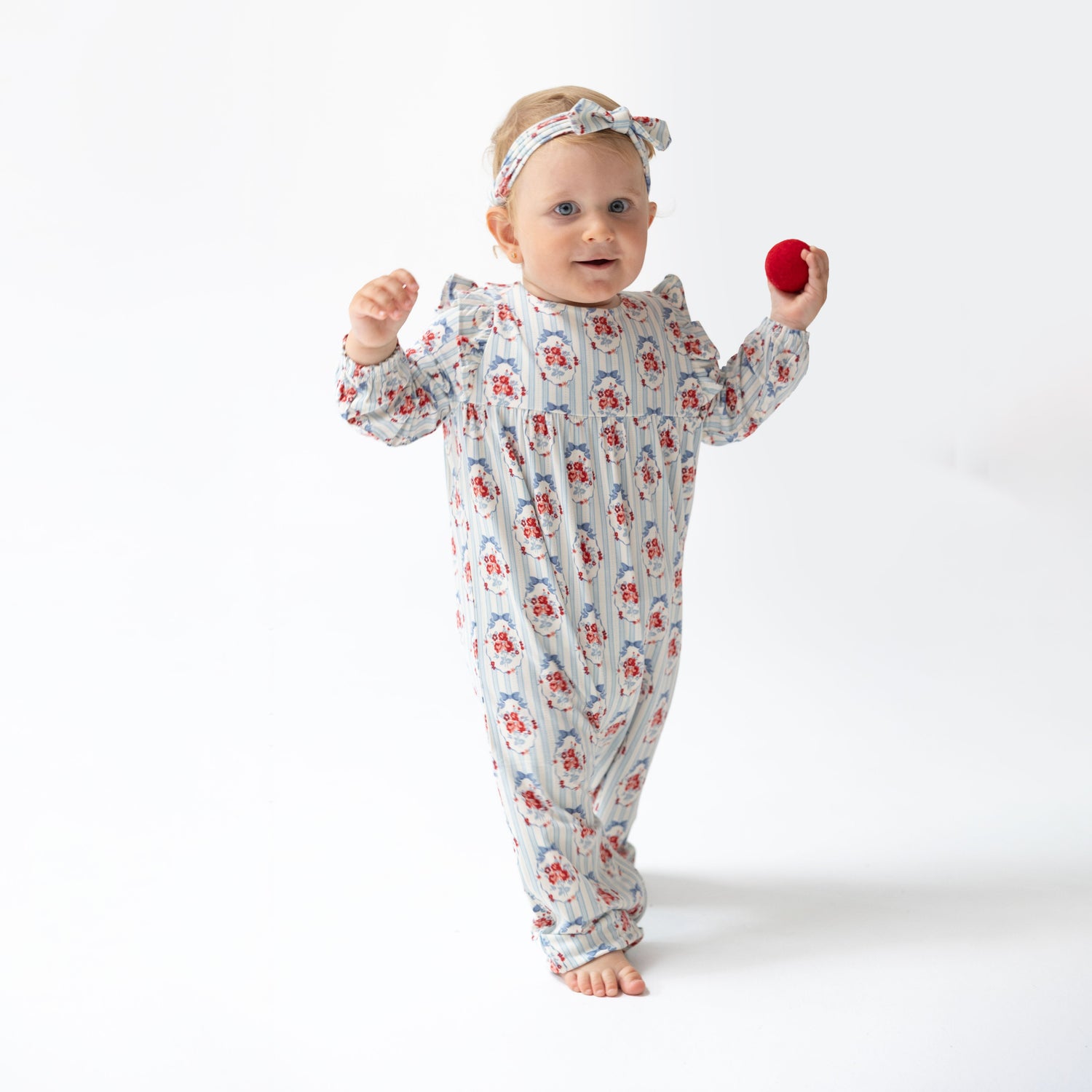Ruffle sleeve snap romper in a soft cameo stripe pattern with short ruffled sleeves and snap closures.
