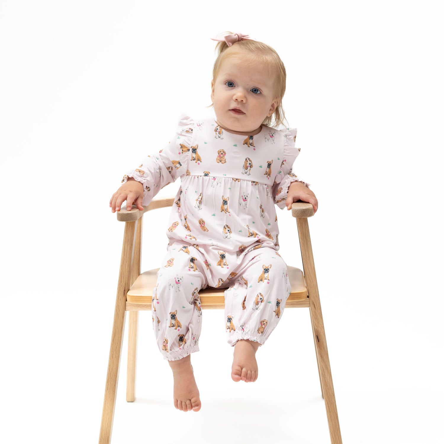 Ruffle-sleeve snap romper in pink with a playful best-friend dogs print and short ruffled sleeves.