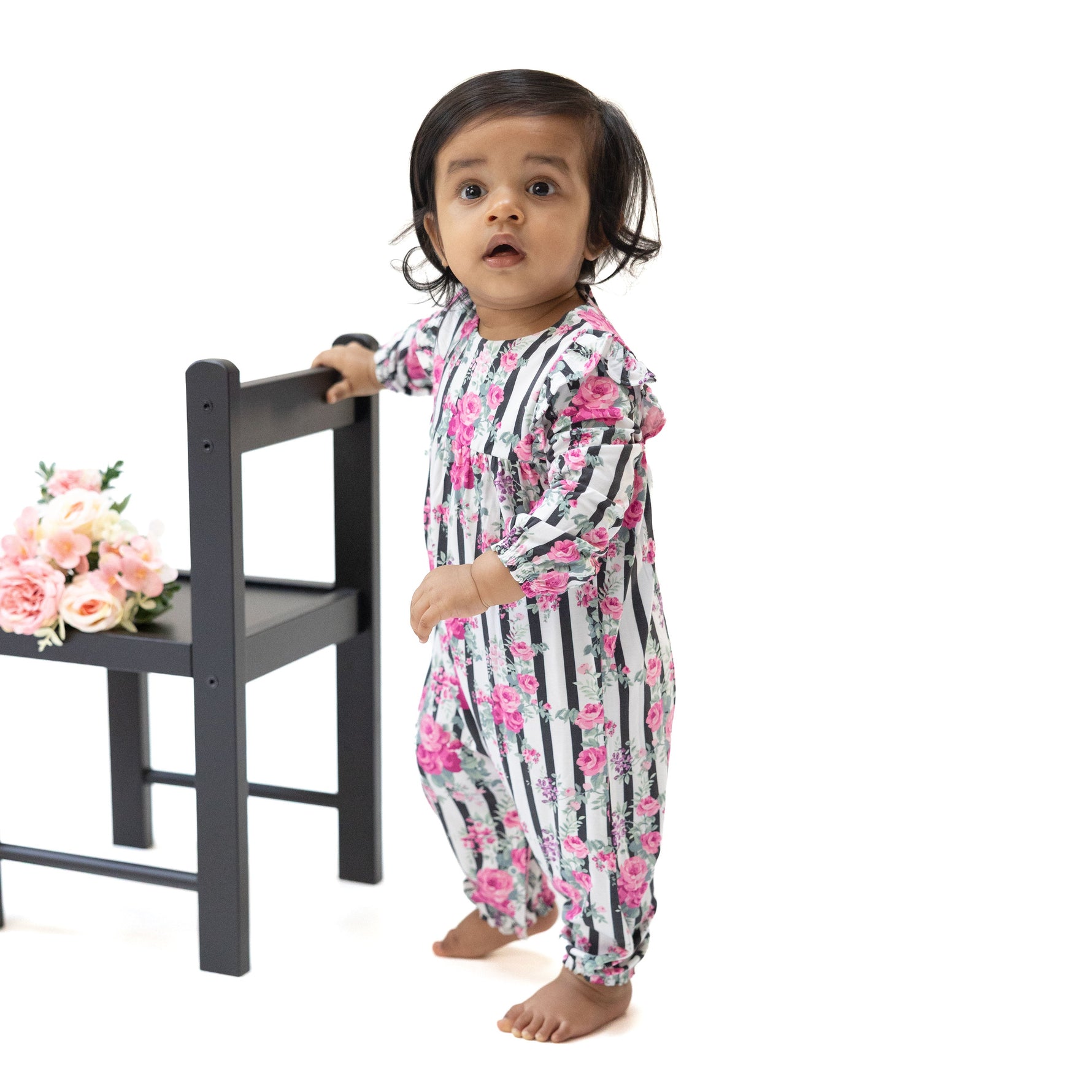 Baby romper in cabbage rose stripe print with ruffle sleeves and snap closures