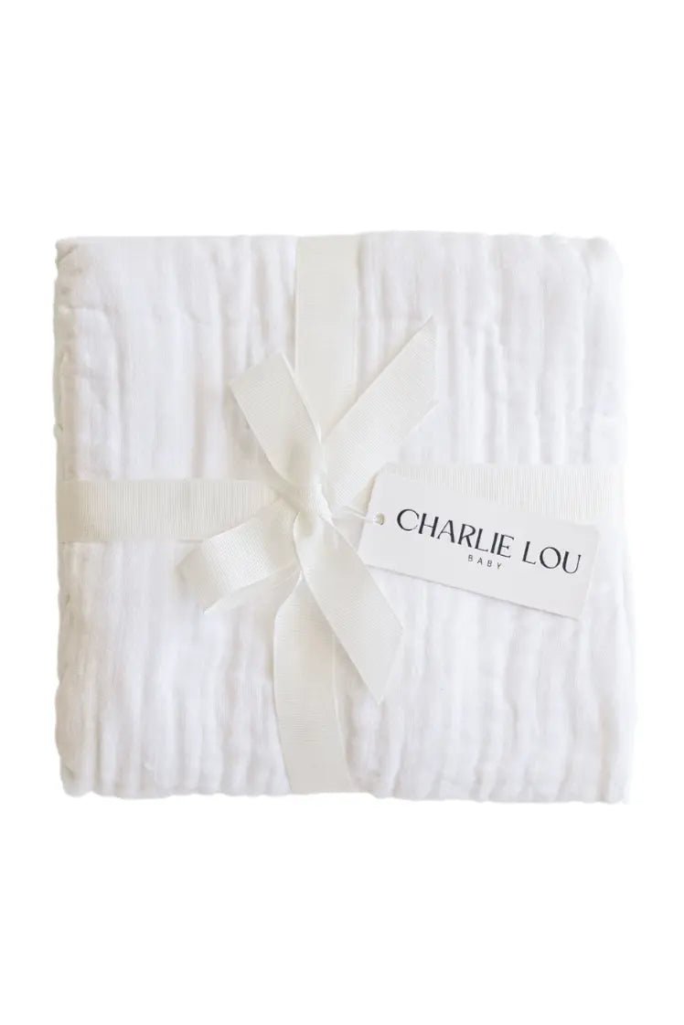 White cotton muslin blanket folded, showing soft layered muslin texture