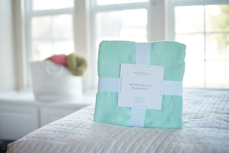 Seafoam green oversized king luxury bamboo bed blanket on a bed with natural light.