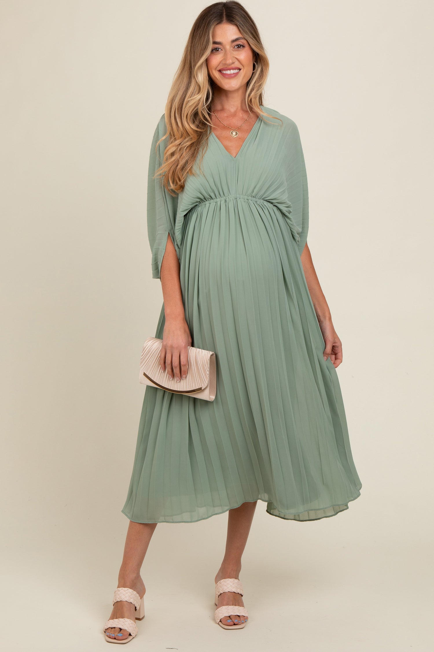 Light olive pleated maternity maxi dress with a V neckline and long flowing skirt