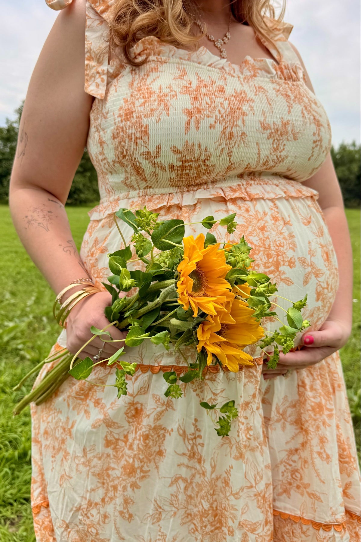 Peach floral sleeveless ruffle tiered maternity midi dress.