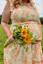 Peach floral sleeveless ruffle tiered maternity midi dress.