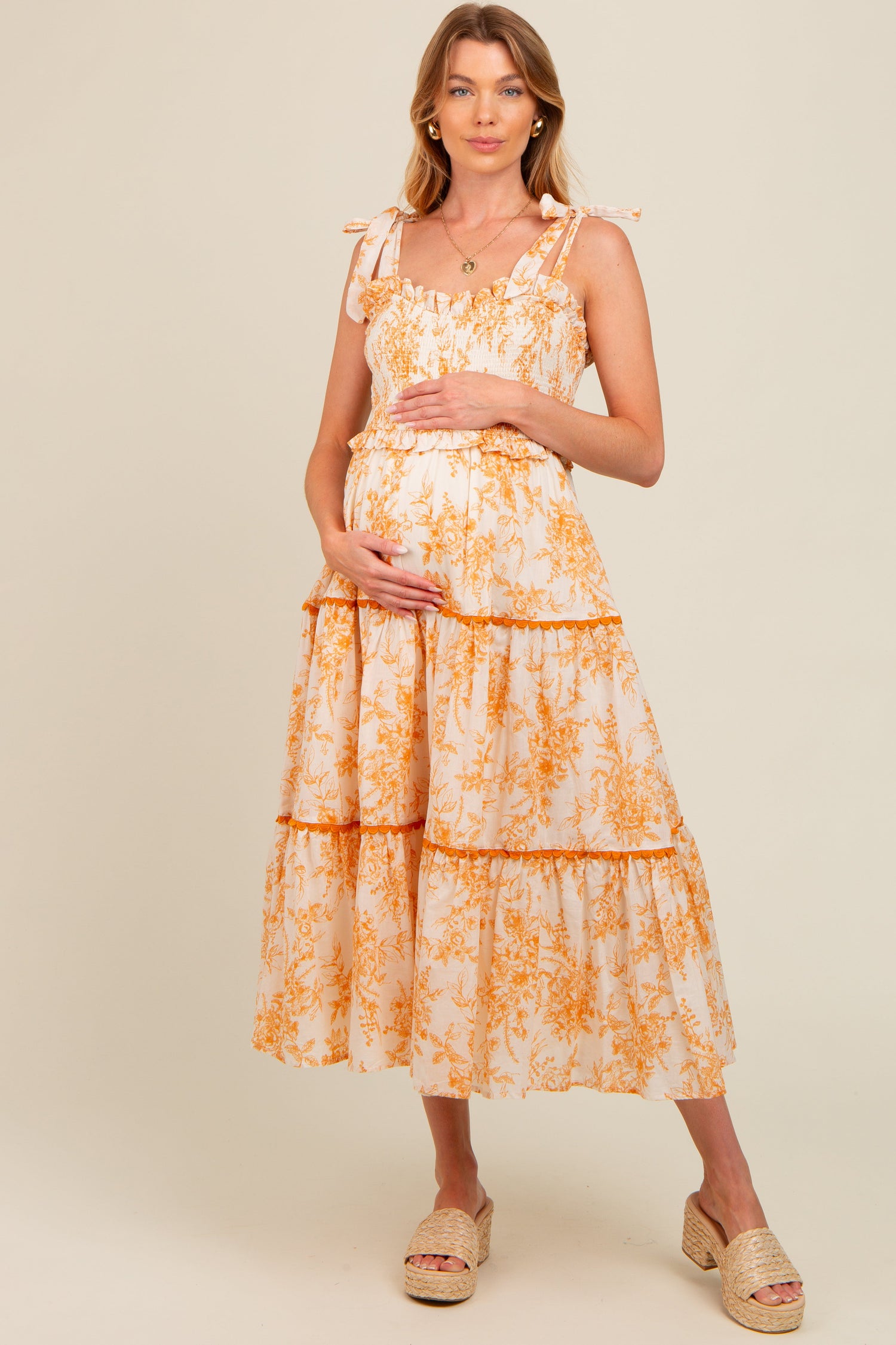 Peach floral sleeveless ruffle tiered maternity midi dress.