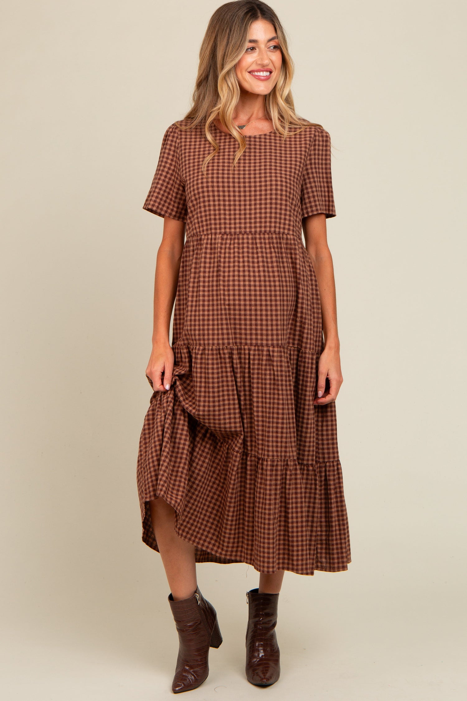 Mocha gingham maternity midi dress with a tiered skirt and relaxed fit over a baby bump