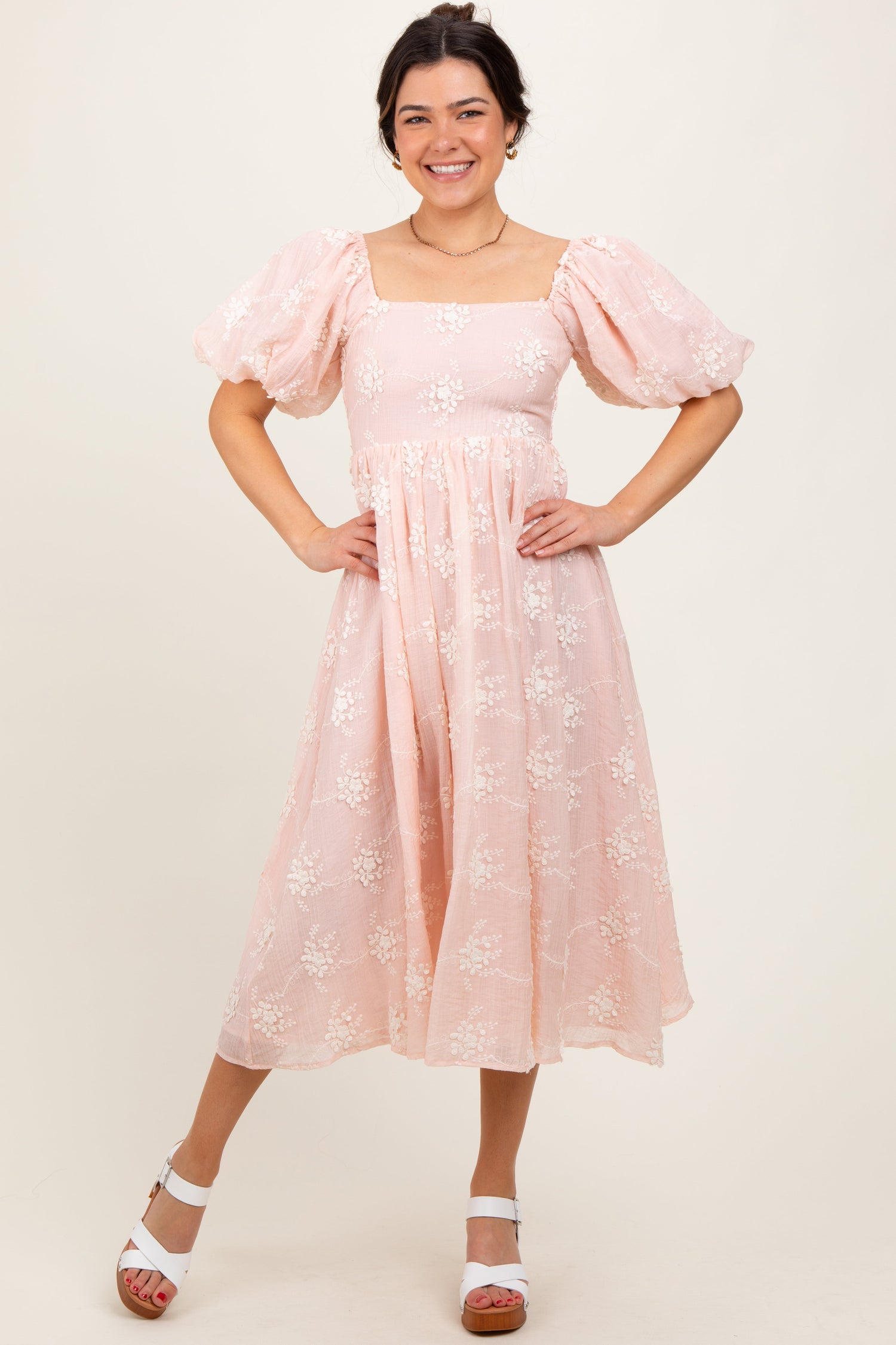 Pink textured floral midi dress with a square neckline, puff sleeves, fitted bodice, and gathered midi skirt