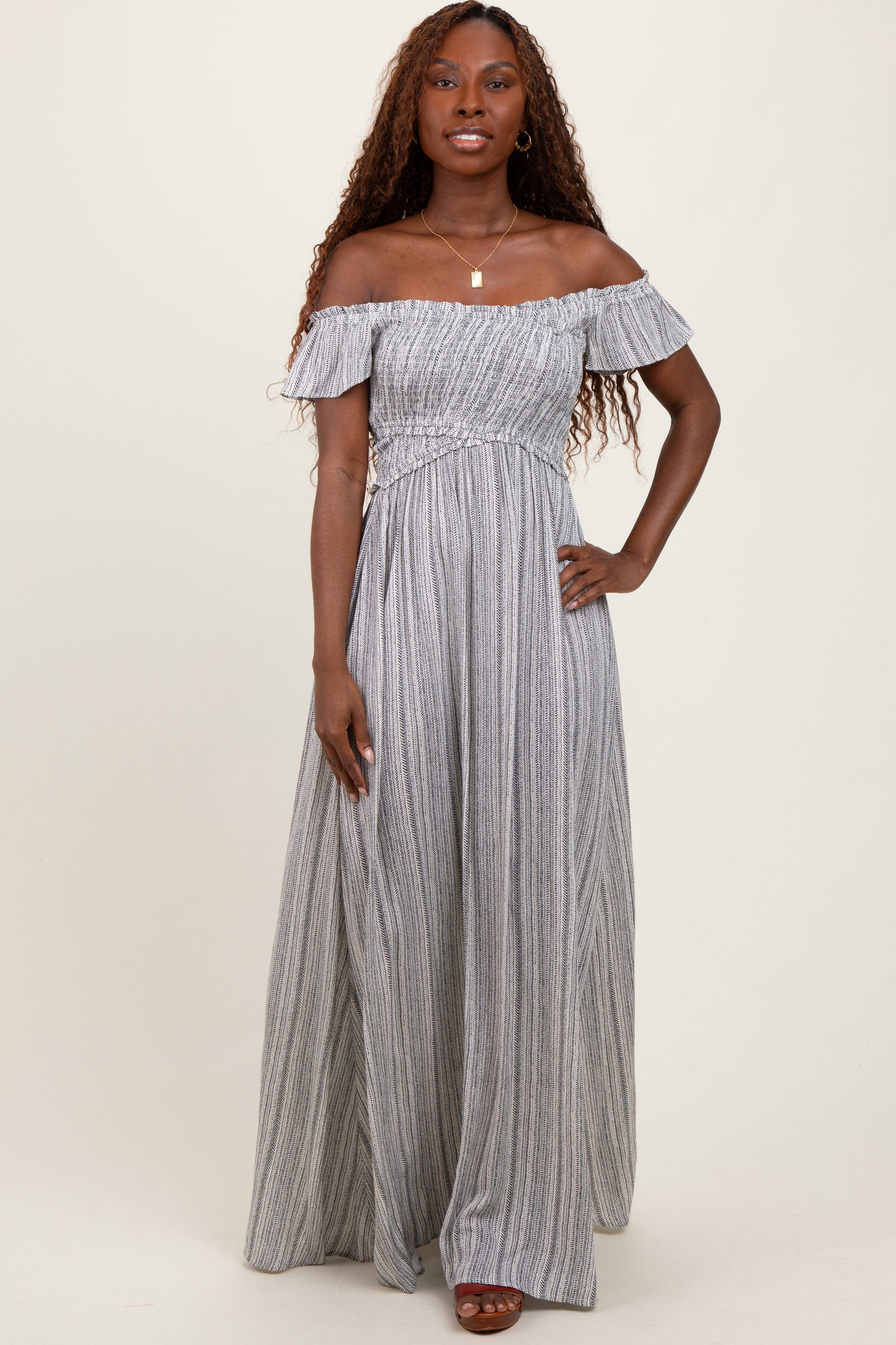 Black off-shoulder maxi dress with ruffle neckline, smocked bodice, and a long flowy skirt.