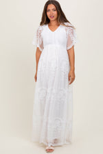White maternity maxi dress with smocked bodice, lace detailing, and a long flowing skirt
