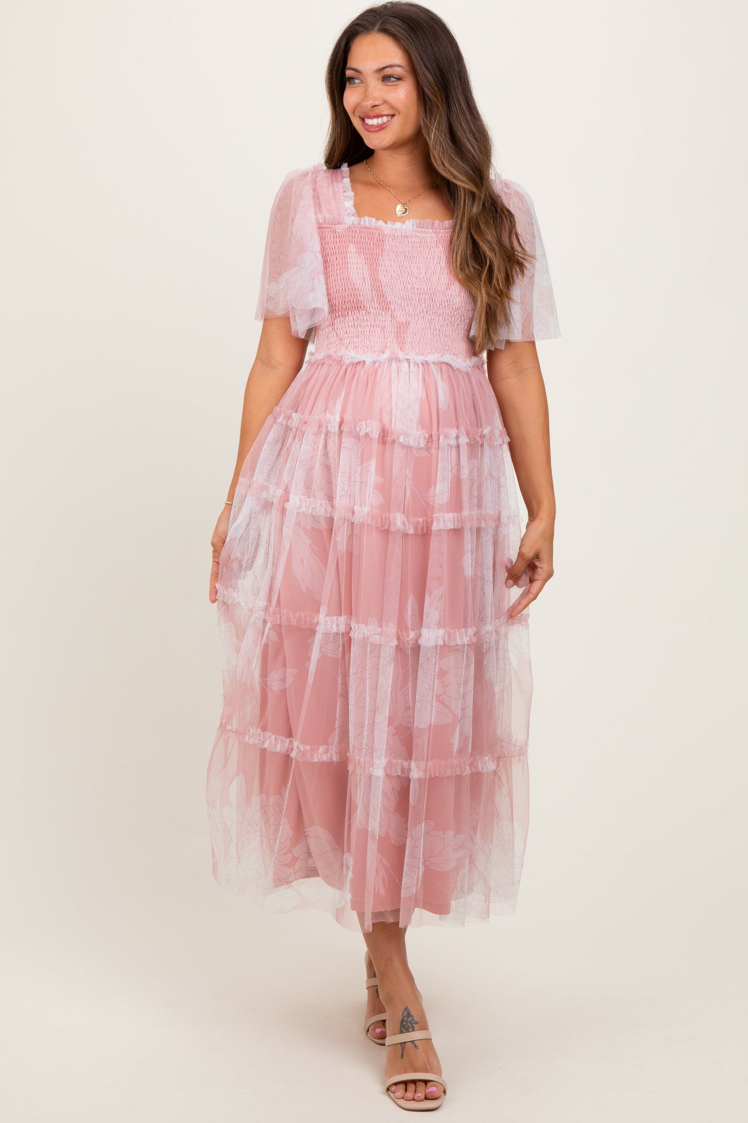 Pink smocked maternity midi dress with mesh ruffles, square neckline, short puff sleeves, and a tiered flowing skirt.