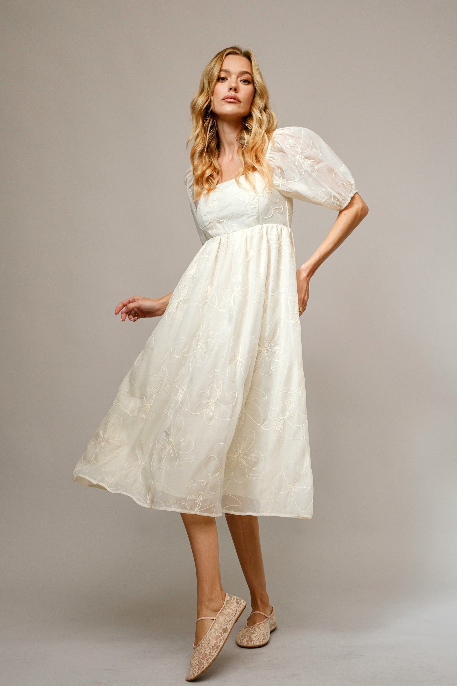 Cream floral embroidered midi dress with puff sleeves and a square neckline in lightweight flowing fabric.