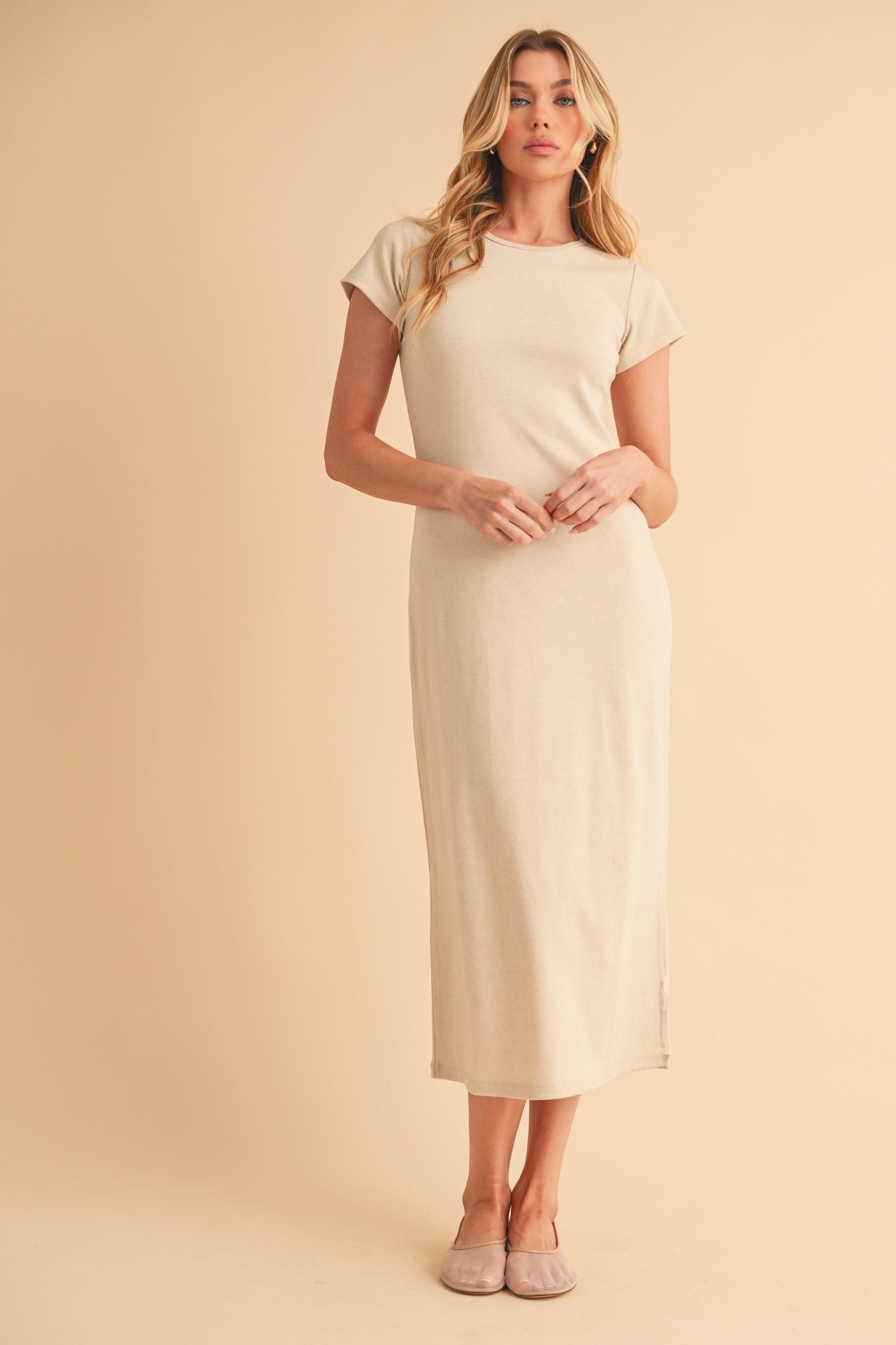 Cream crewneck short-sleeve midi dress worn with sandals by a standing model.