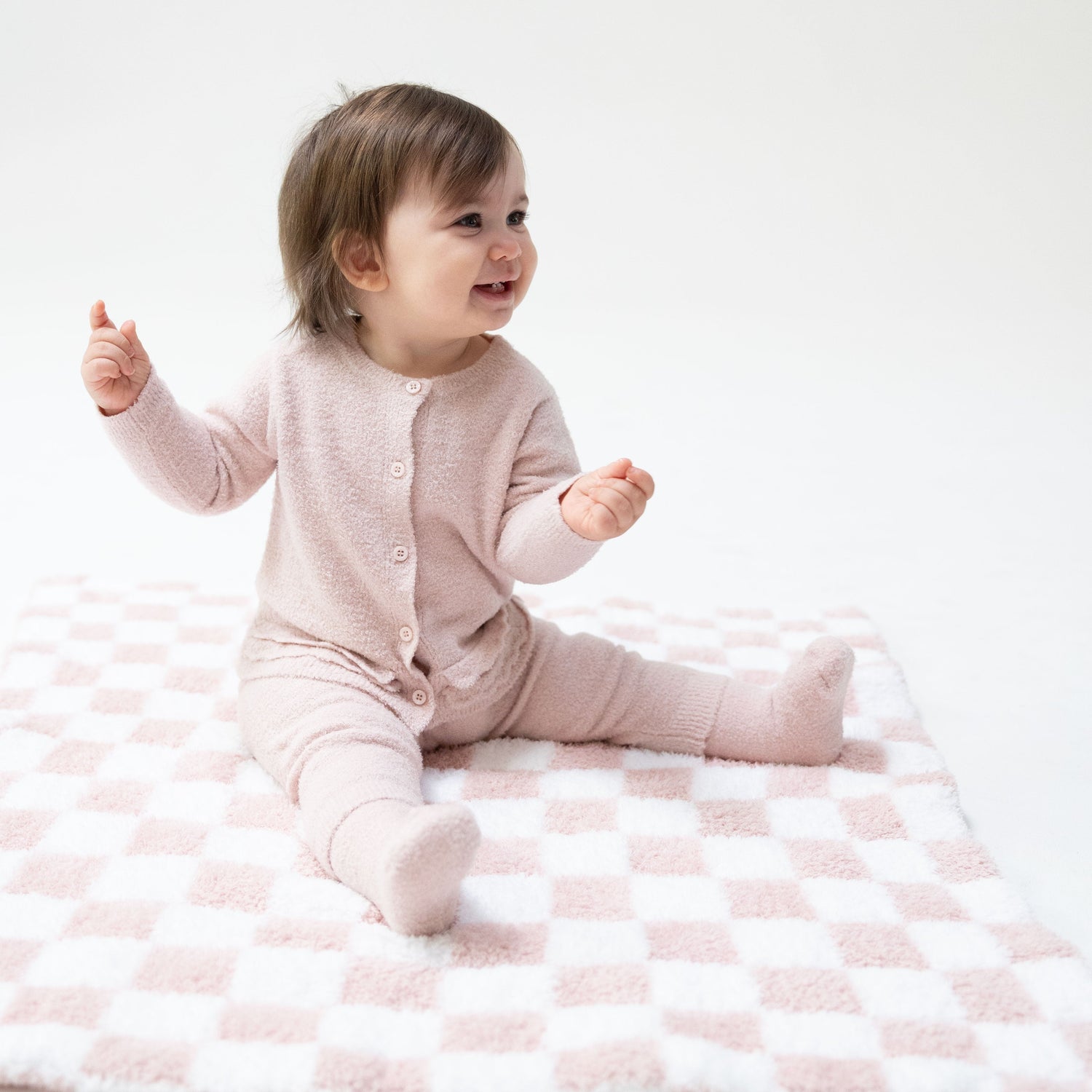Chenille baby stroller blanket in a blush pink and white checkerboard pattern.