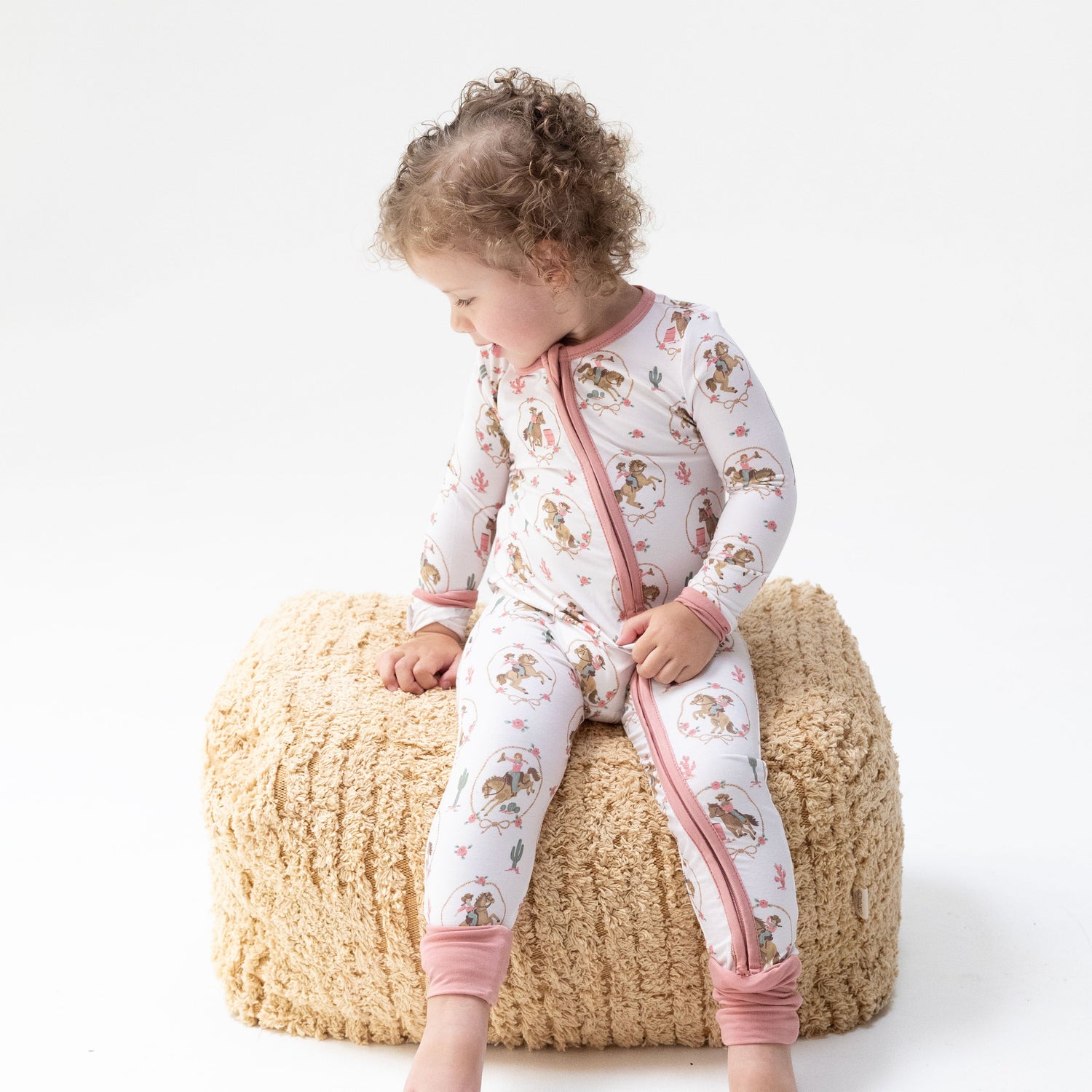 Convertible baby romper in Cowgirl Cameos print with two-way zipper and foot cuffs