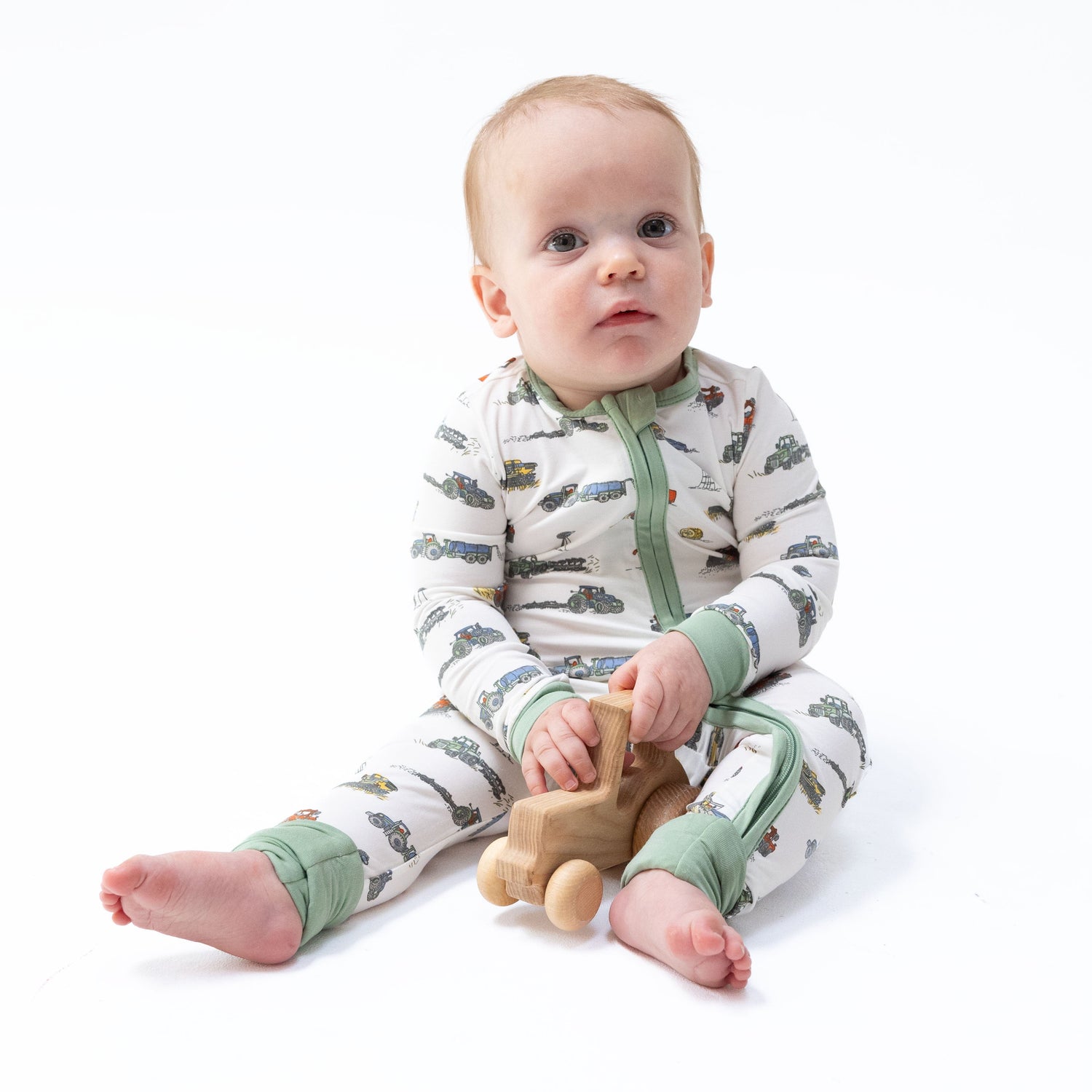 Convertible romper in a farm machines print with tractors and trucks, two-way zipper and footed cuffs