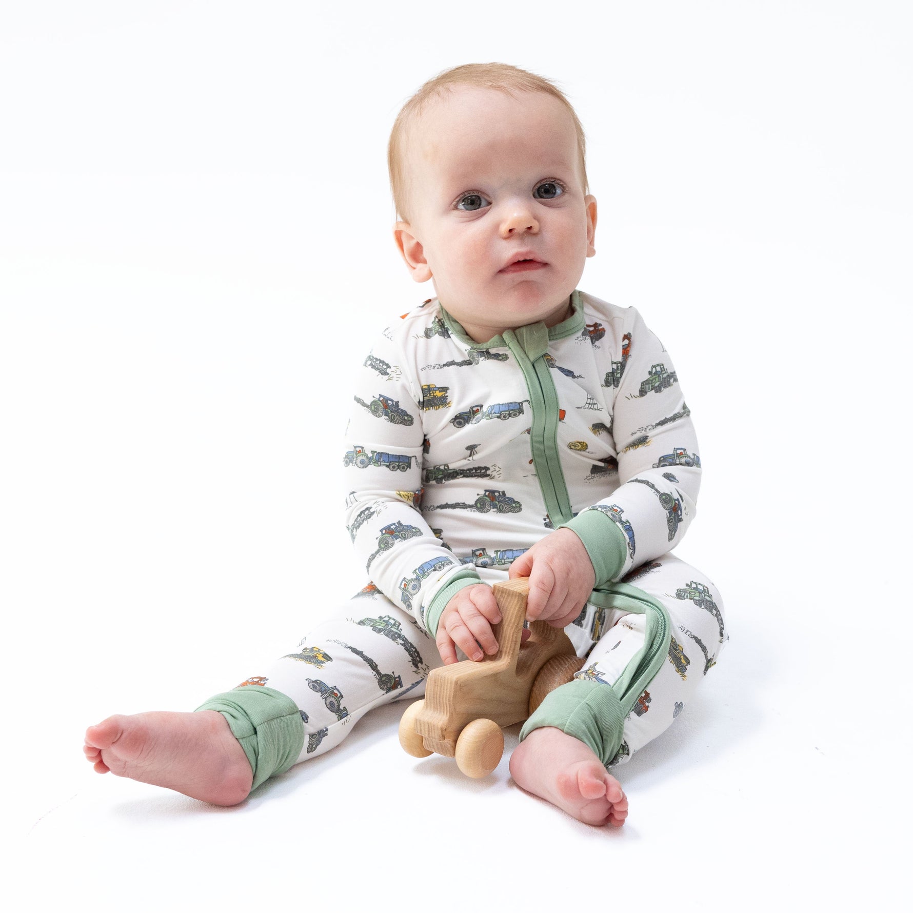 Convertible romper in a farm machines print with tractors and trucks, two-way zipper and footed cuffs
