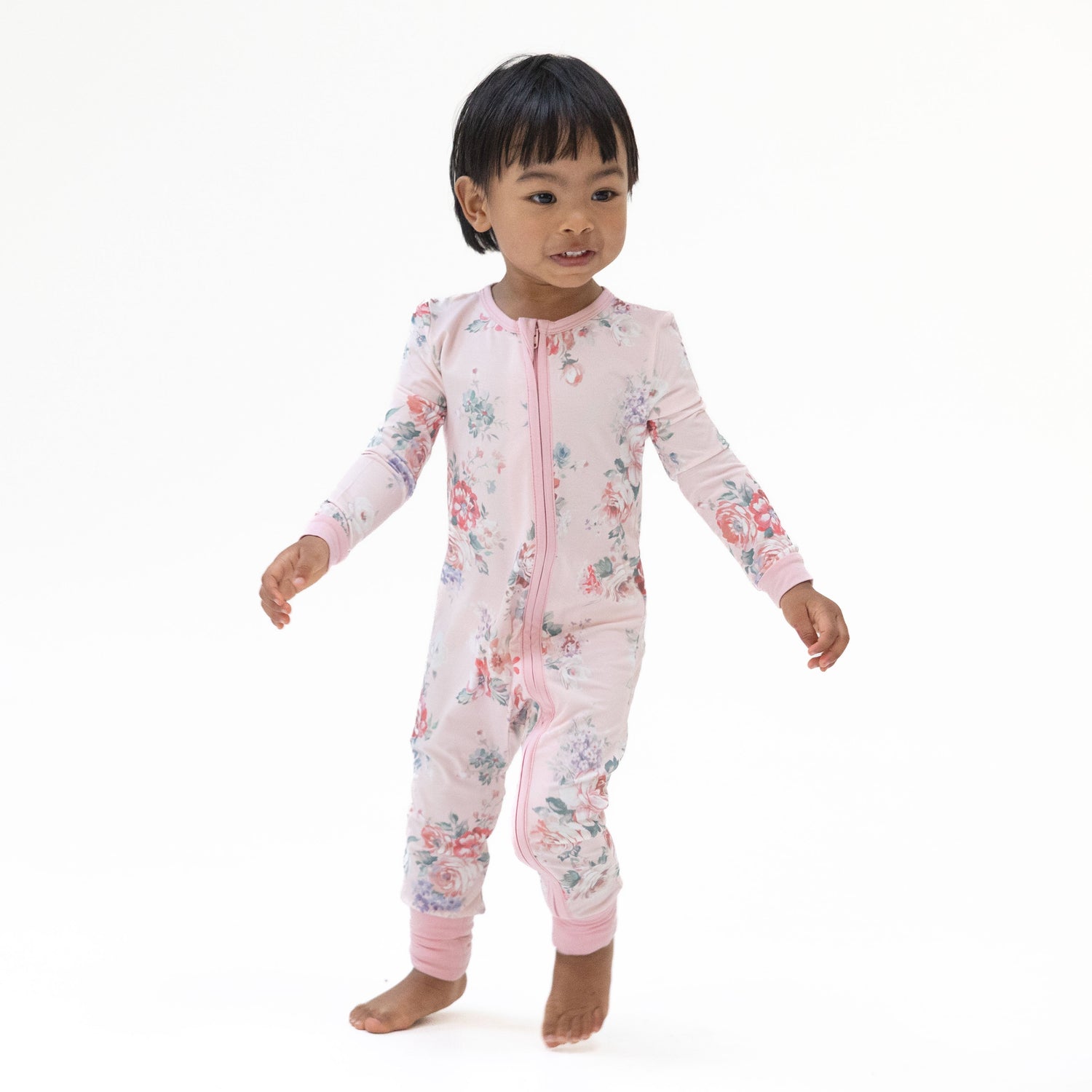 Convertible romper with a painterly rose bouquet print in soft pink and green tones, featuring a full-length zipper.