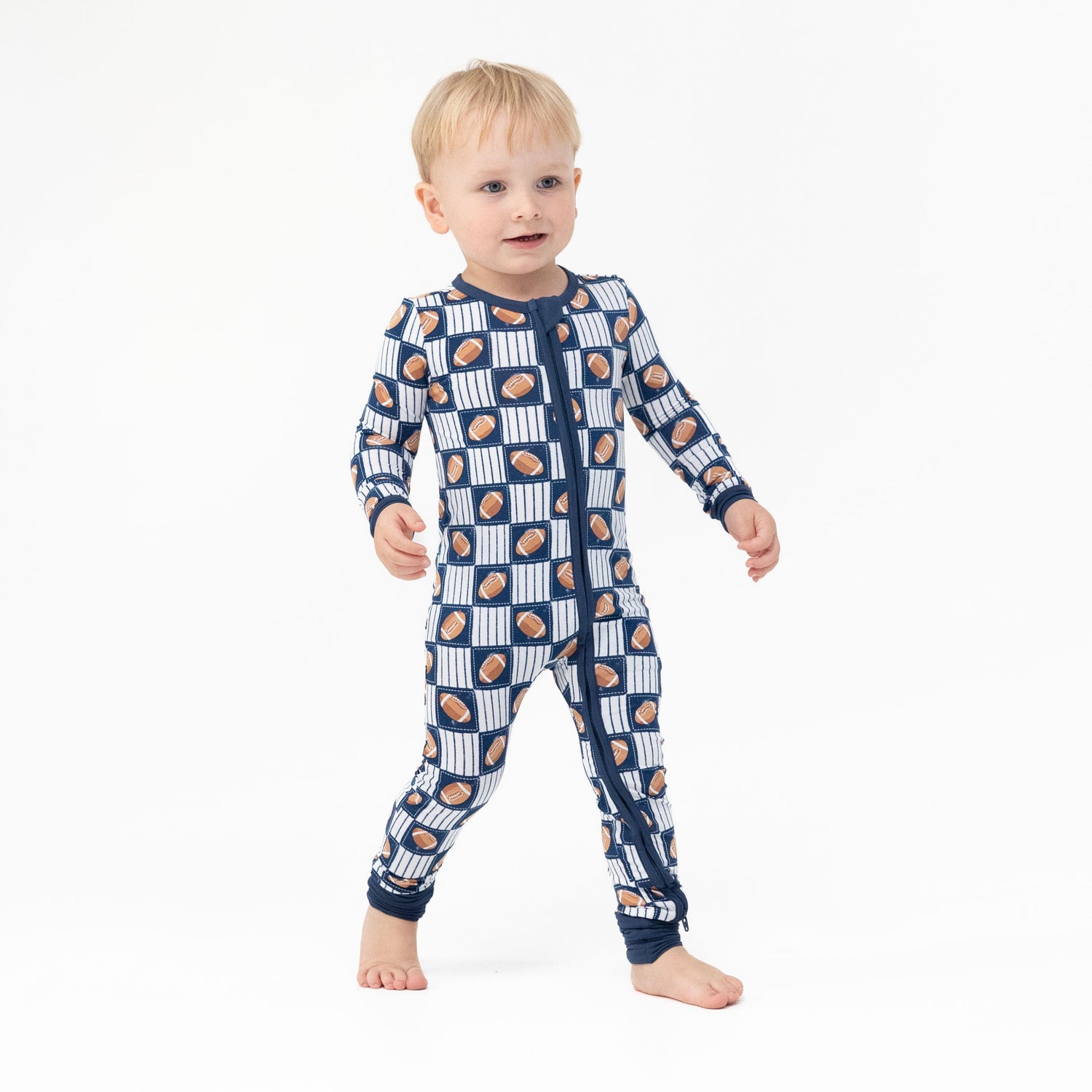 Convertible romper with all-over football patchwork print, two-way zipper, and foot cuffs