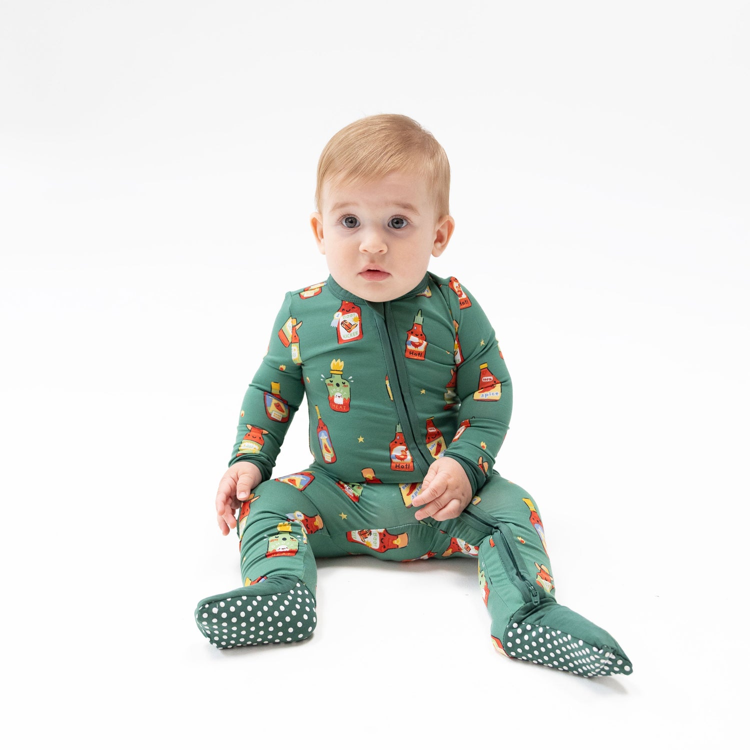 Convertible romper with a warm spice-toned print, two-way zipper, and covered feet with grippers