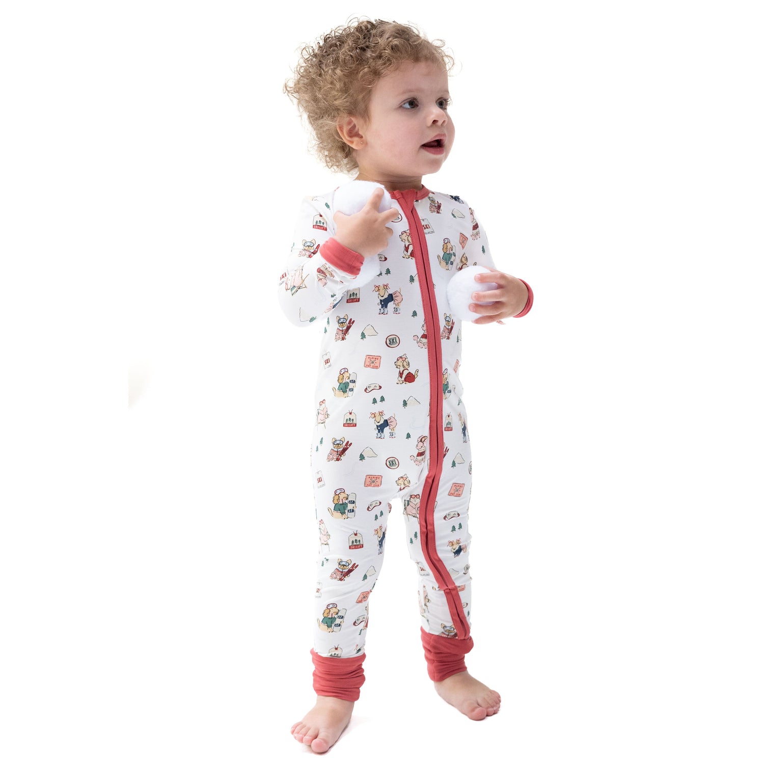 Convertible romper in pink with print of little dogs on skis and skates, featuring a zipper and fold-over cuffs