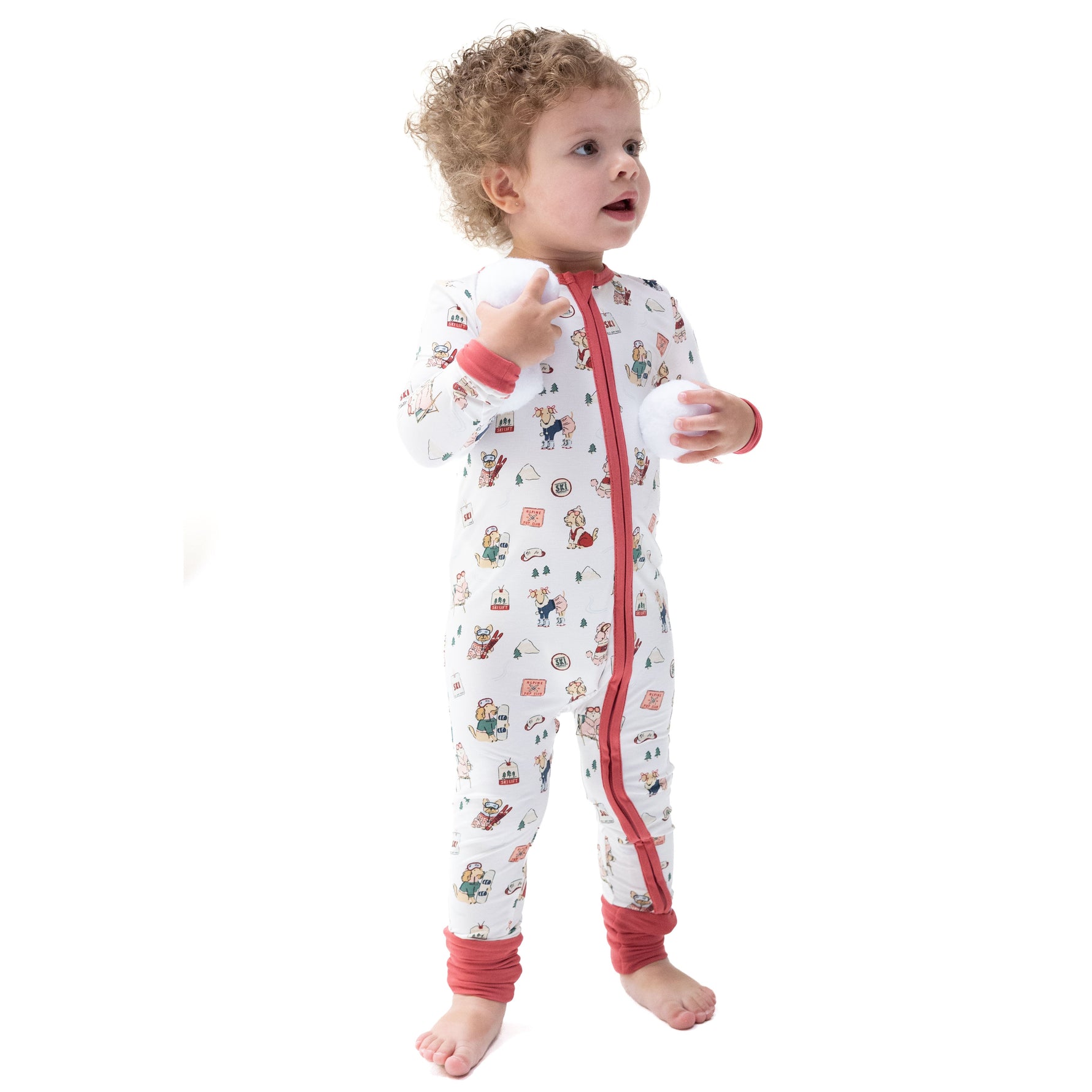 Convertible romper in pink with print of little dogs on skis and skates, featuring a zipper and fold-over cuffs