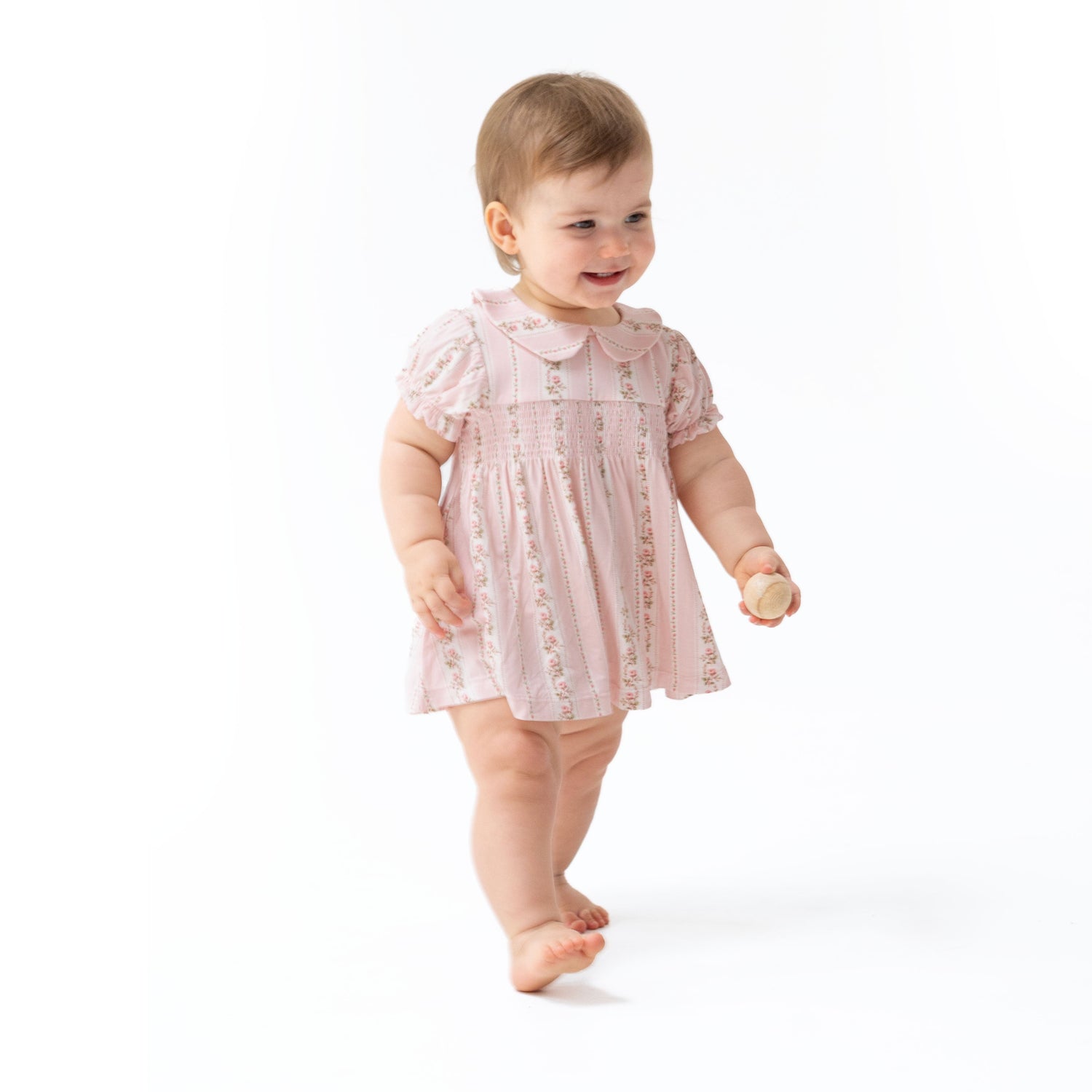 Striped smocked dress set with Peter Pan collar, ruffle trim, and elastic sleeves and legs.