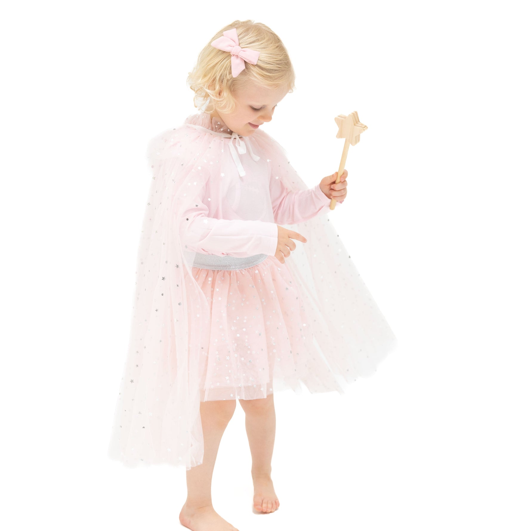 Soft pink tulle play cape with silver foil stars and a tie closure at the neck