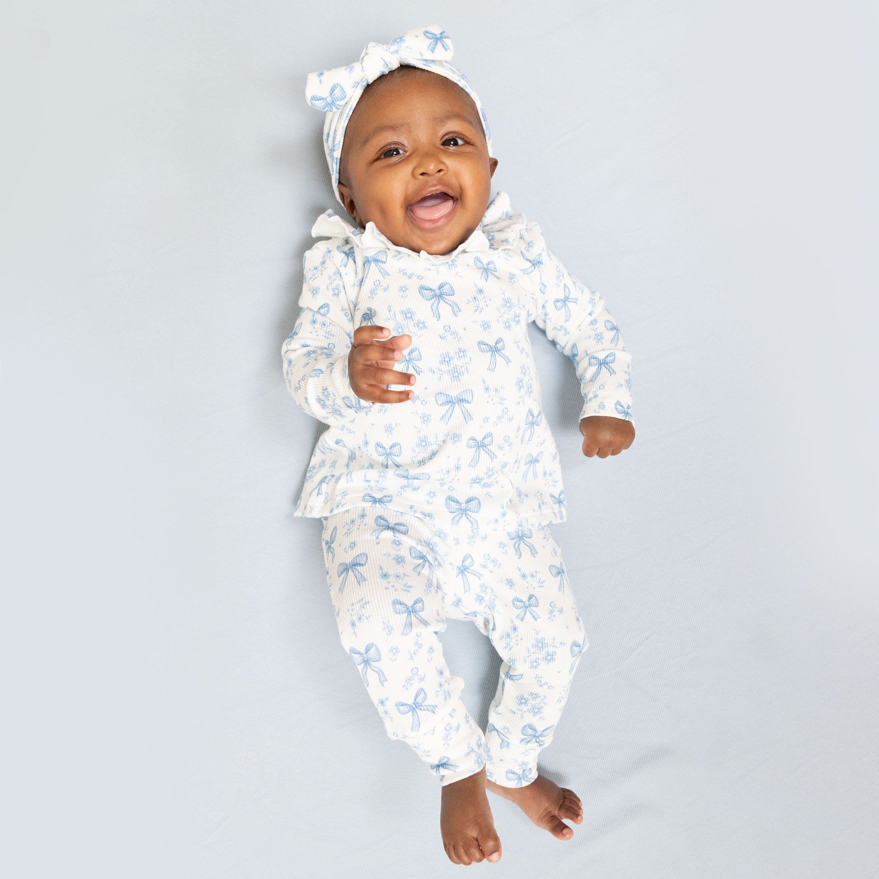 Two-piece baby set: long sleeve ruffle-collar top and pants in a blue bows and flowers print