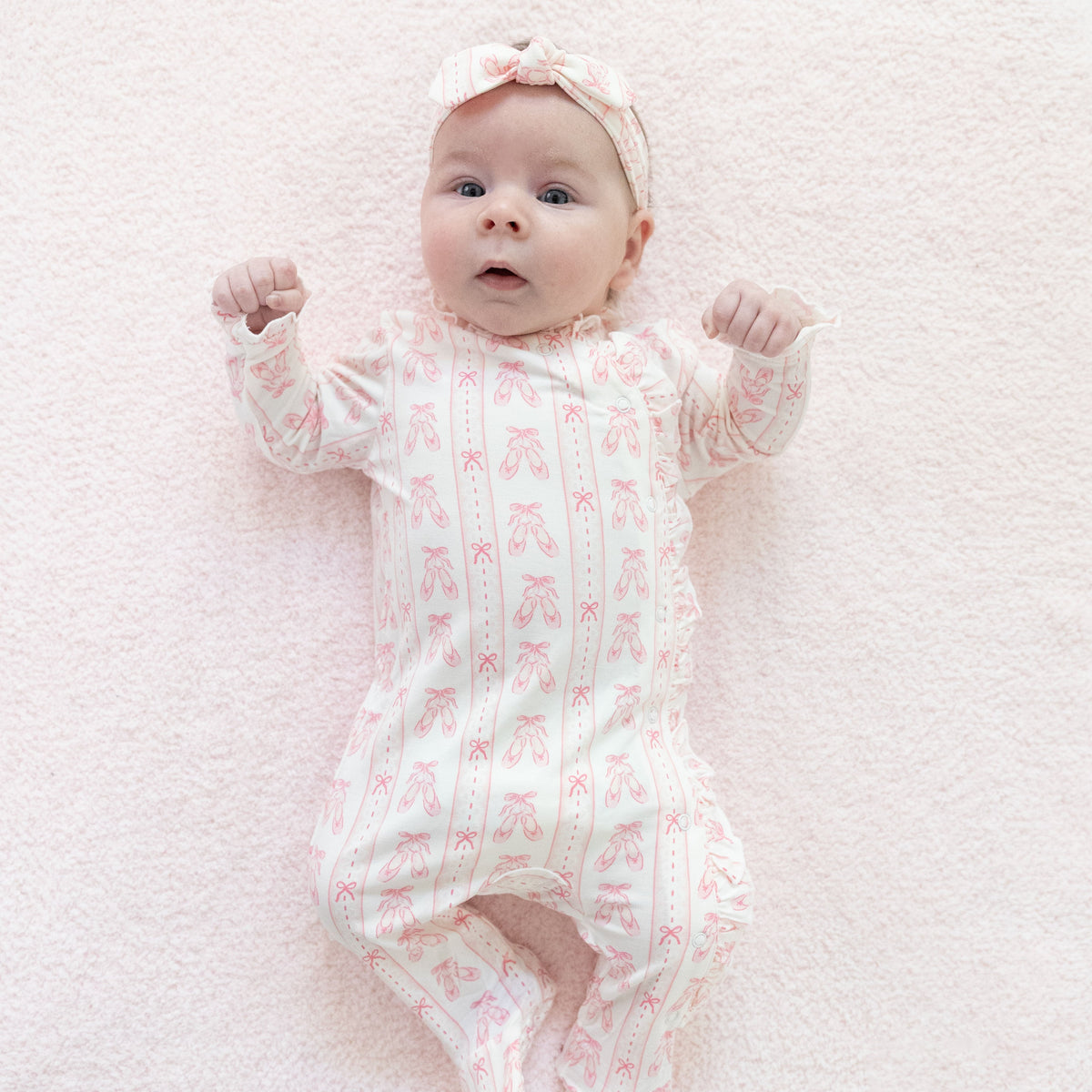 Kimono-style baby footie in pink ribbon stripe with ruffle wrap front, snap closures, and covered feet