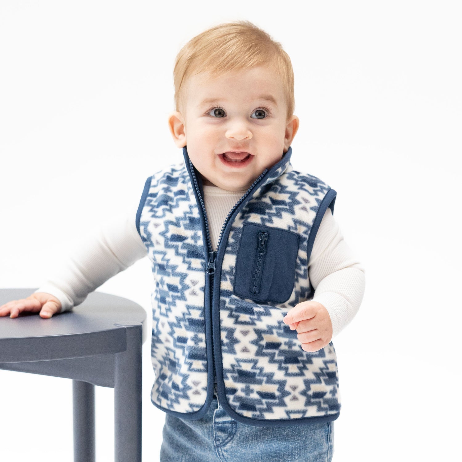 Sleeveless baby zip vest in Southwest-print micro fleece with a front zip pocket and full-length zipper.