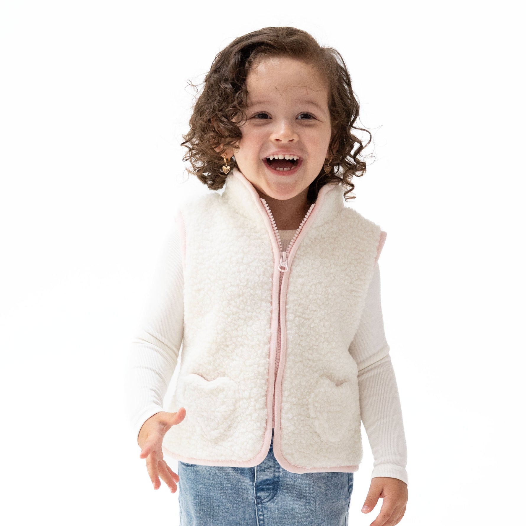 Sleeveless sherpa zip vest with heart-shaped front pockets and contrast piping trim.