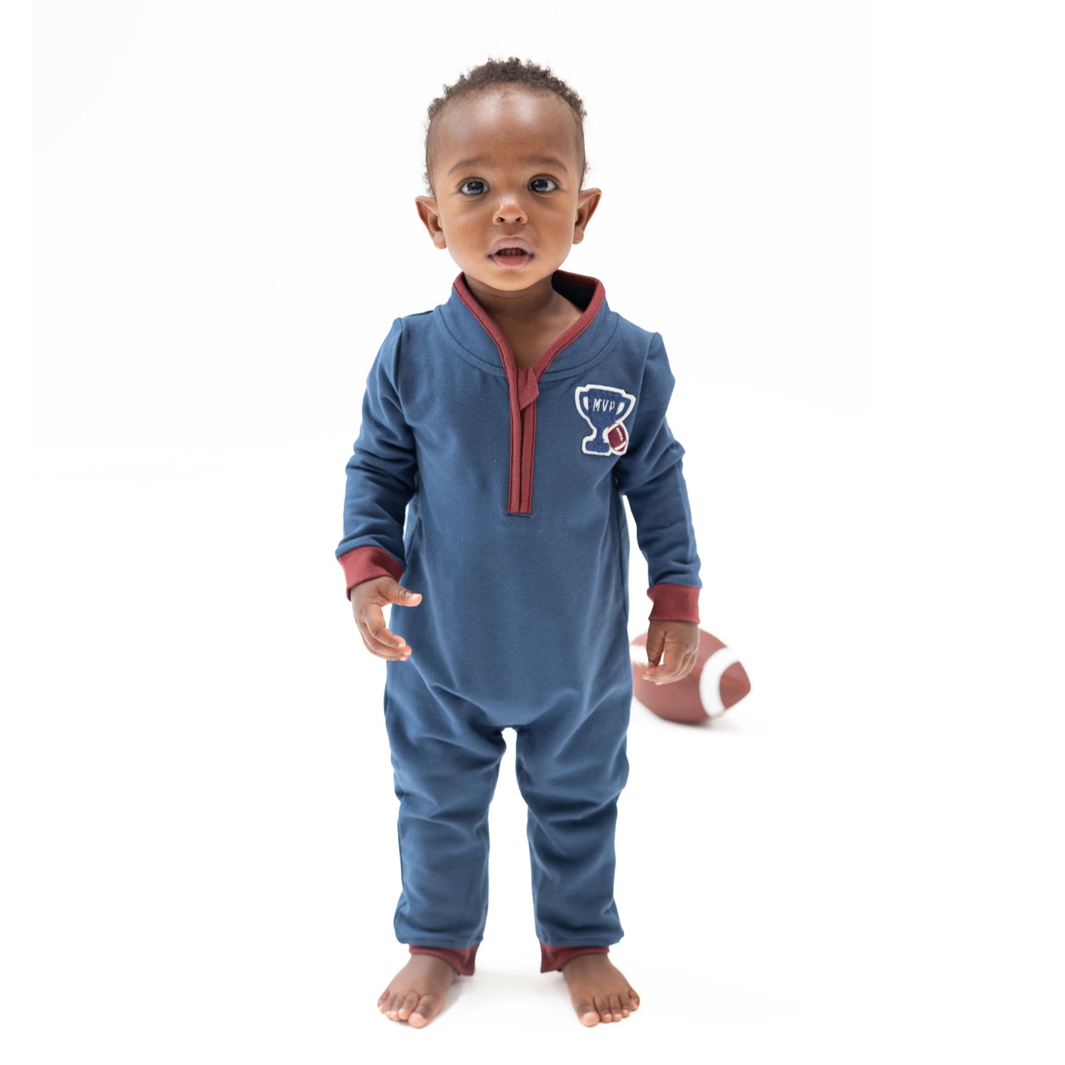 Zip neck baby romper in varsity French terry with an MVP trophy applique on the left side and ribbed cuffs.