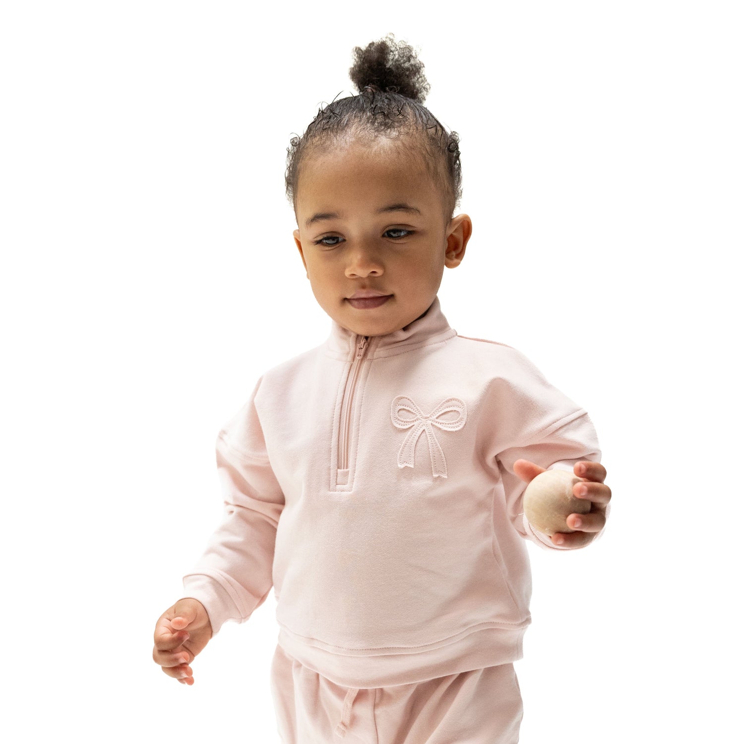 Pink half zip sweatshirt with a bow applique on the left chest and ribbed cuffs
