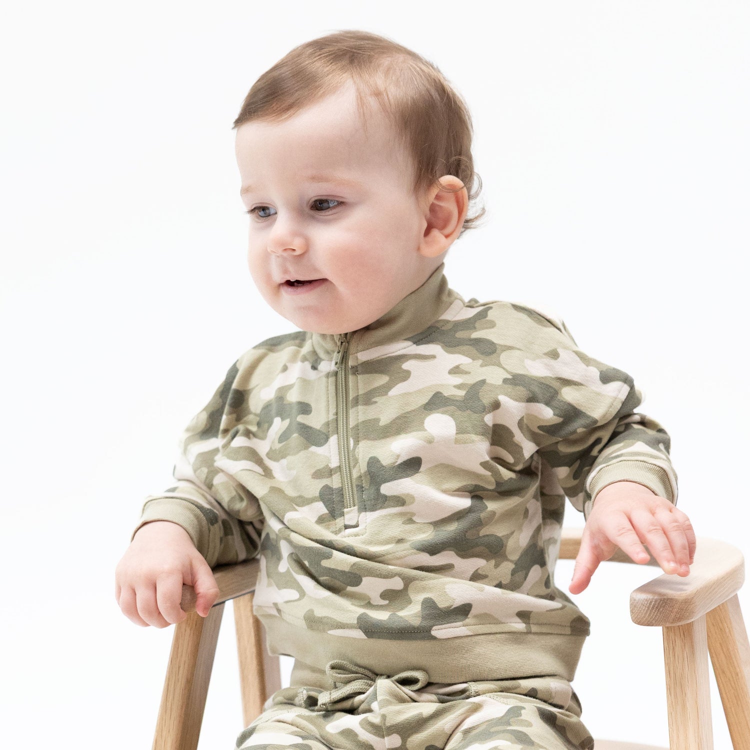 Half zip baby sweatshirt in camo-print organic French terry with ribbed cuffs and a front zipper.