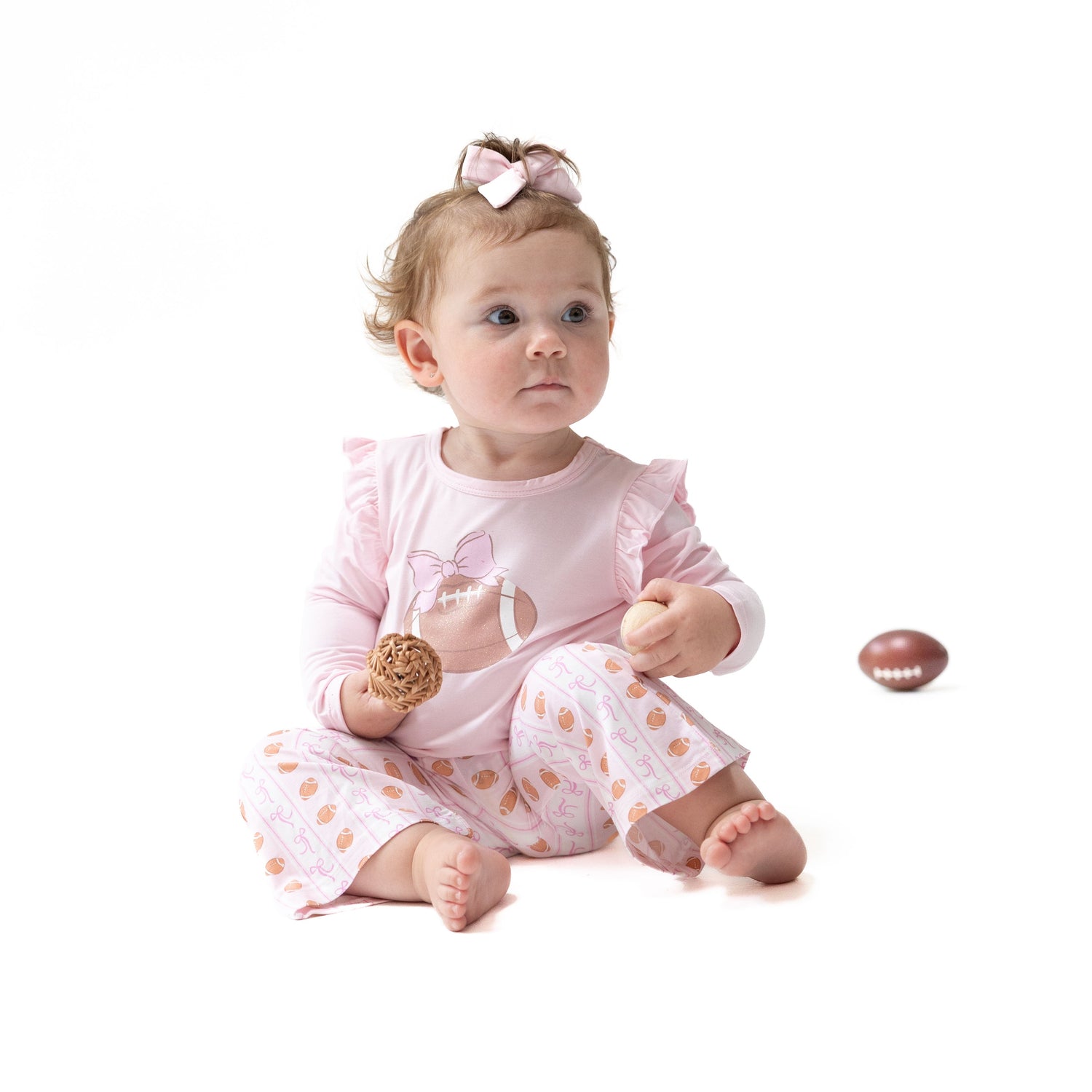 Baby two-piece set with long-sleeve ruffle tee and striped bells featuring a football and bow sparkle print.