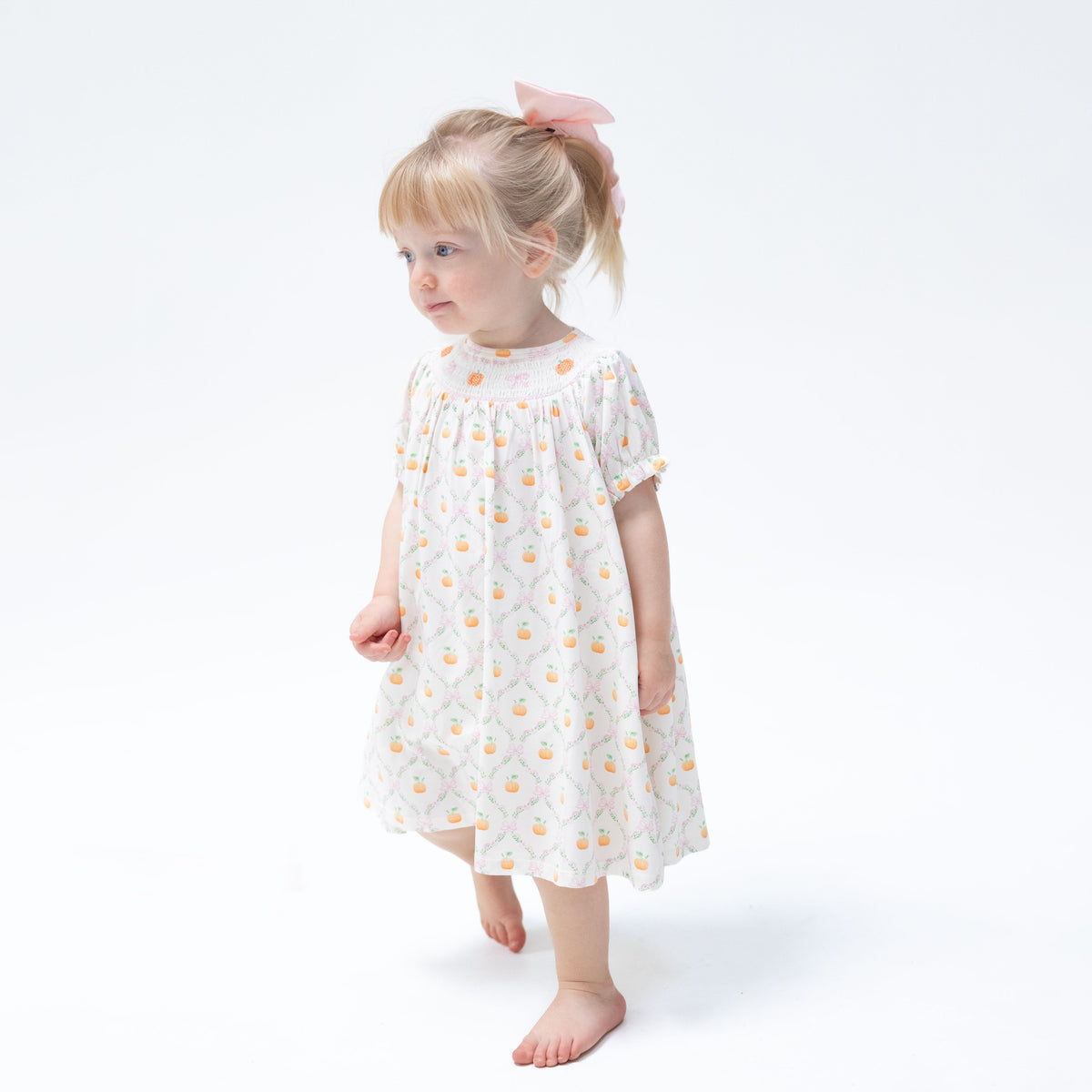 Baby bishop dress with orange pumpkin trellis print, smocked collar and puff sleeves, with matching bloomer