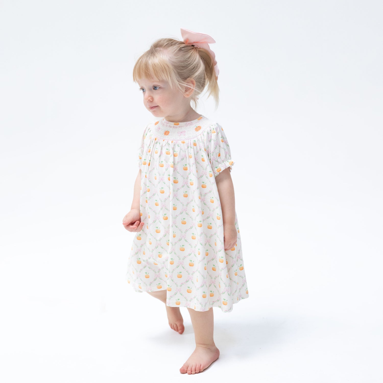 Baby bishop dress with orange pumpkin trellis print, smocked collar and puff sleeves, with matching bloomer