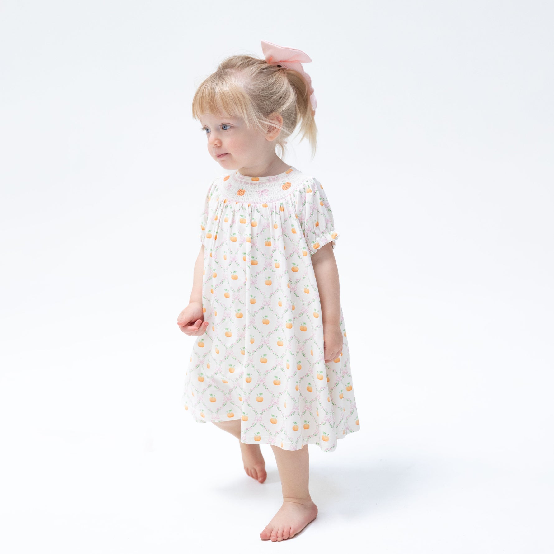 Baby bishop dress with orange pumpkin trellis print, smocked collar and puff sleeves, with matching bloomer