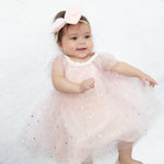 Soft pink velour baby dress with silver foil star tulle overlay, flutter sleeves and keyhole back opening