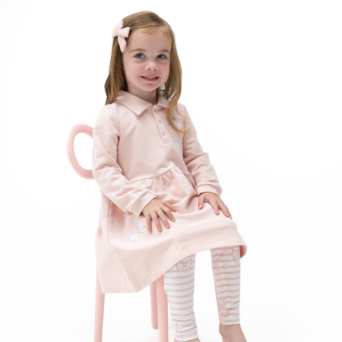 Veiled pink collared polo dress with button placket and bow appliques, shown with matching leggings with knee bow embroidery