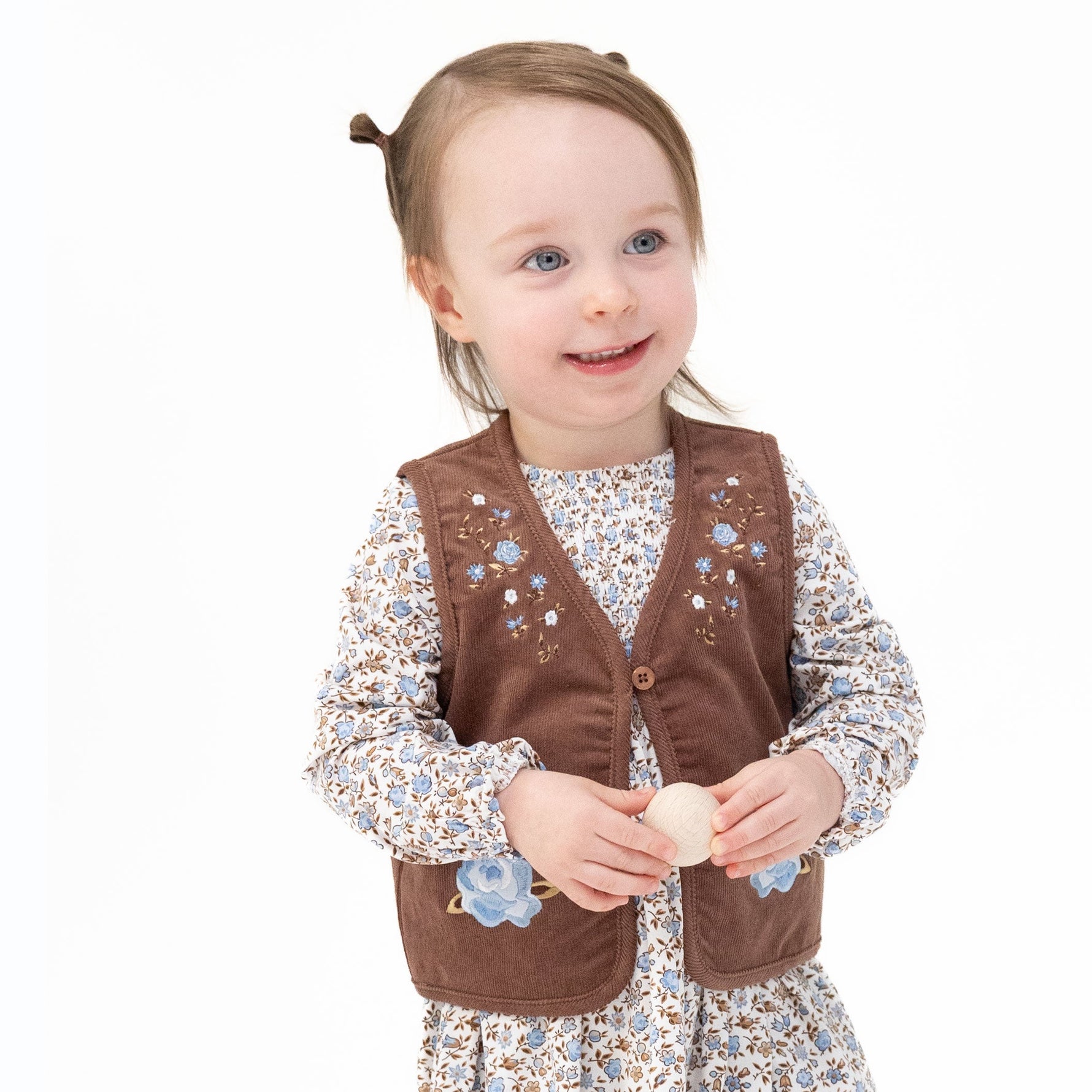 Baby vest in corduroy with embroidered floral details and button loop front closure
