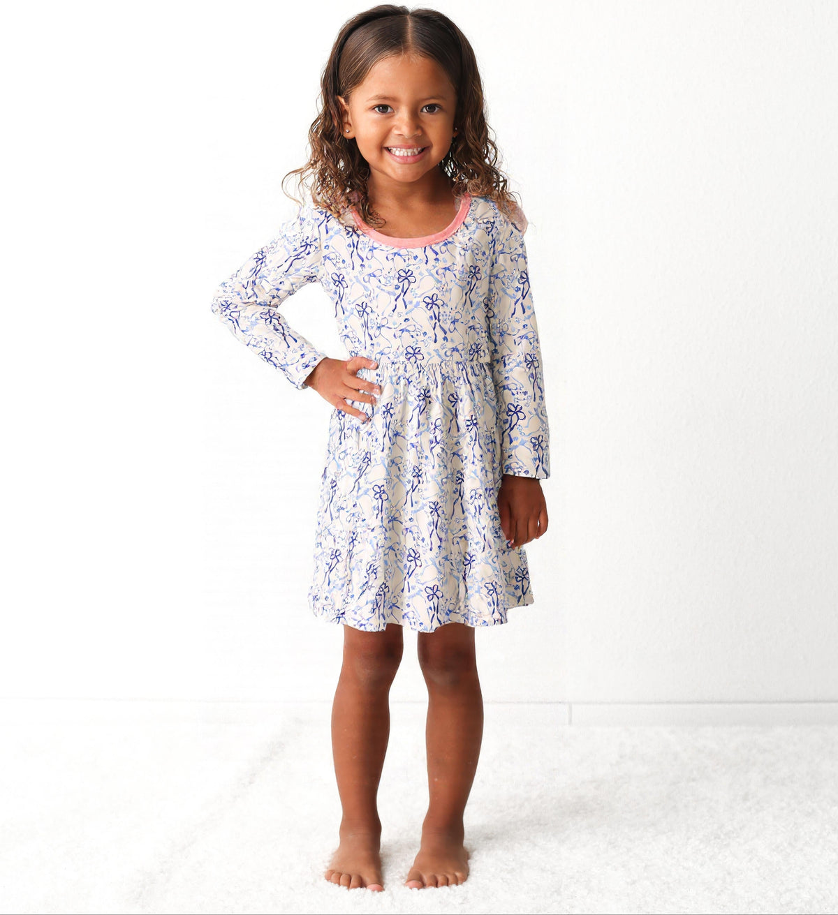 Long-sleeve toddler dress with blue bows, menorahs, dreidels, and Star of David print.