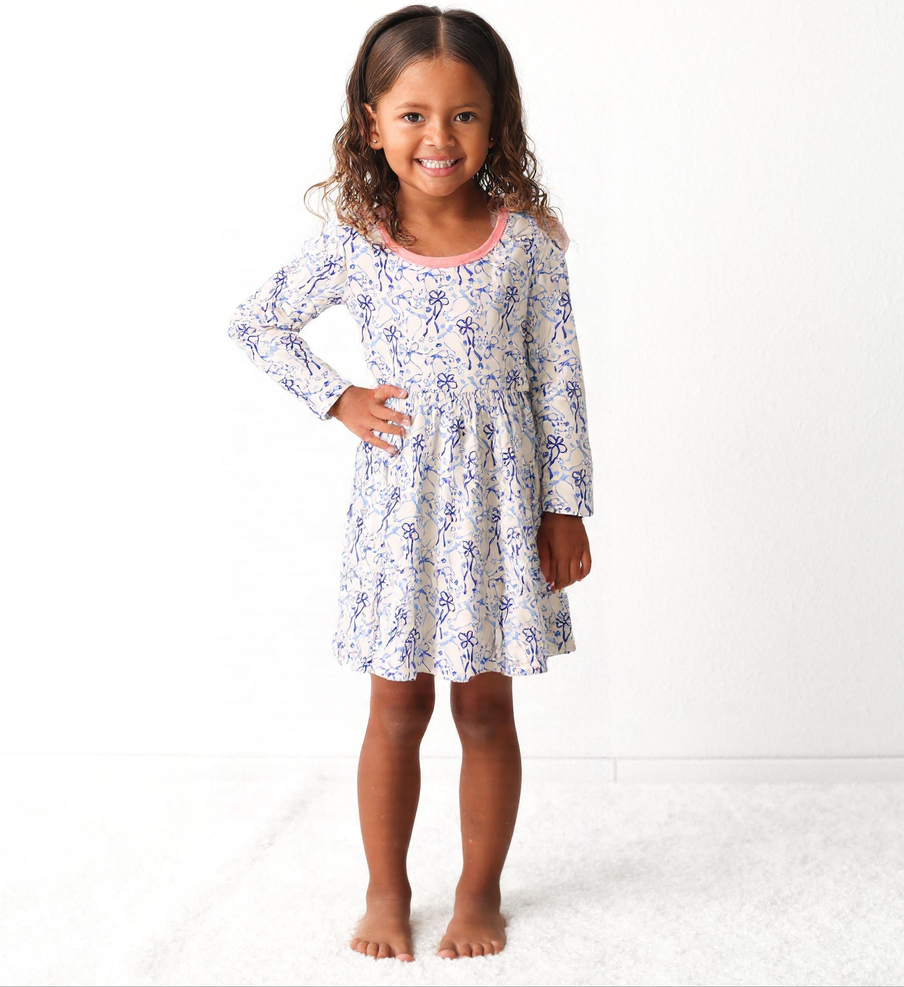 Long-sleeve toddler dress with blue bows, menorahs, dreidels, and Star of David print.