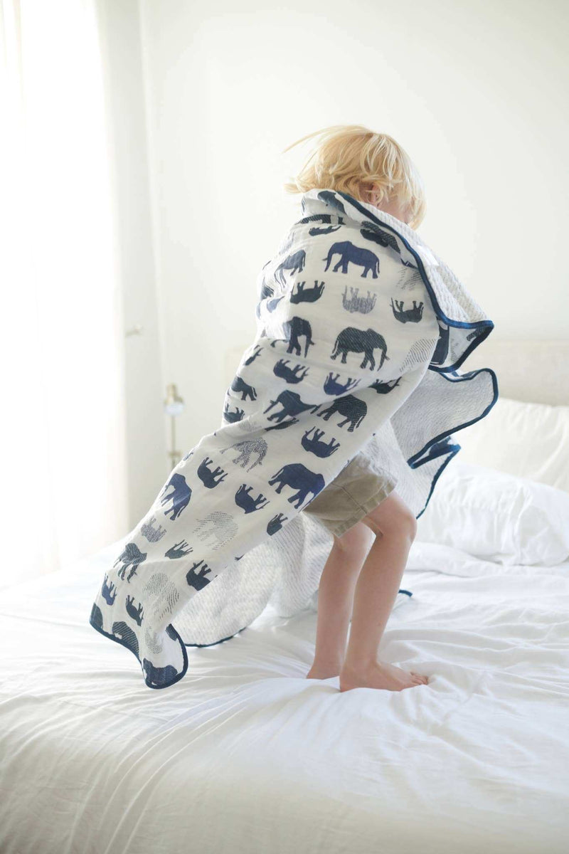 Newcastle Classics blue elephant and spotted wave cotton muslin blanket on bed.