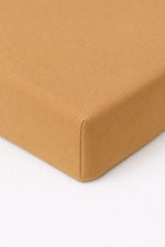 Solid brown crib sheet fitted over a standard crib mattress