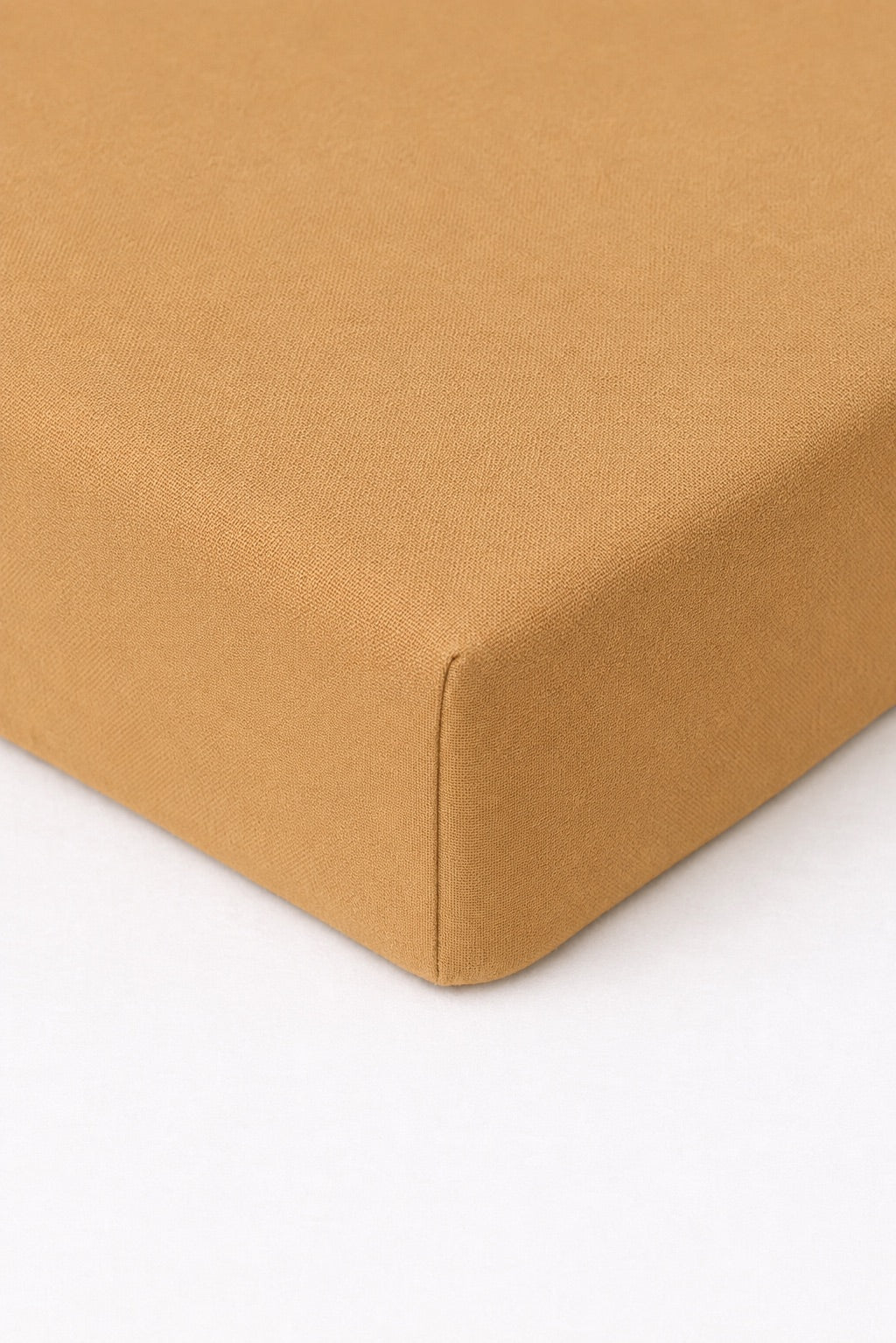 Solid brown crib sheet fitted over a standard crib mattress