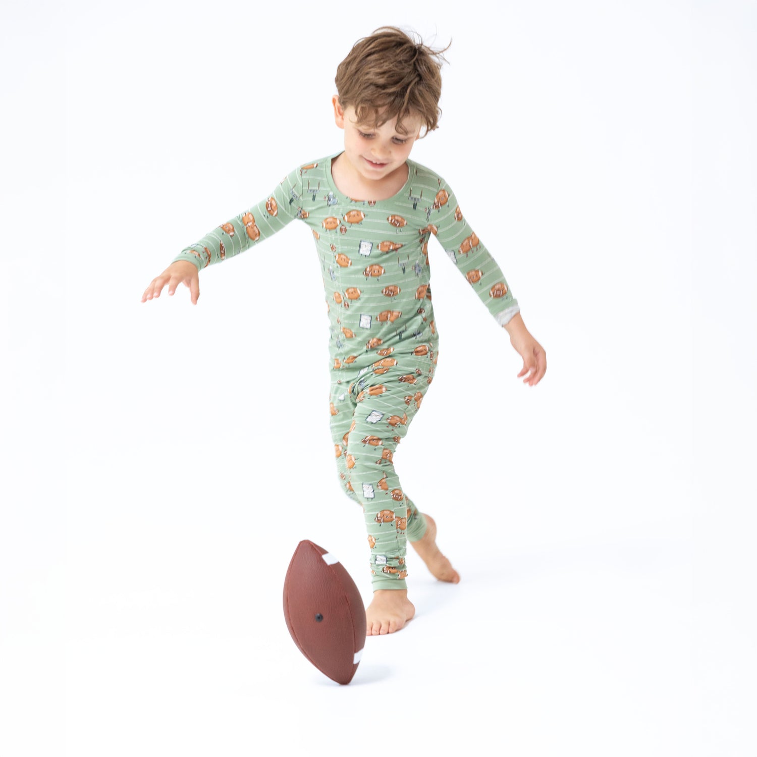 Two-piece long sleeve loungewear set printed with cartoon footballs playing football, shirt and matching pants.